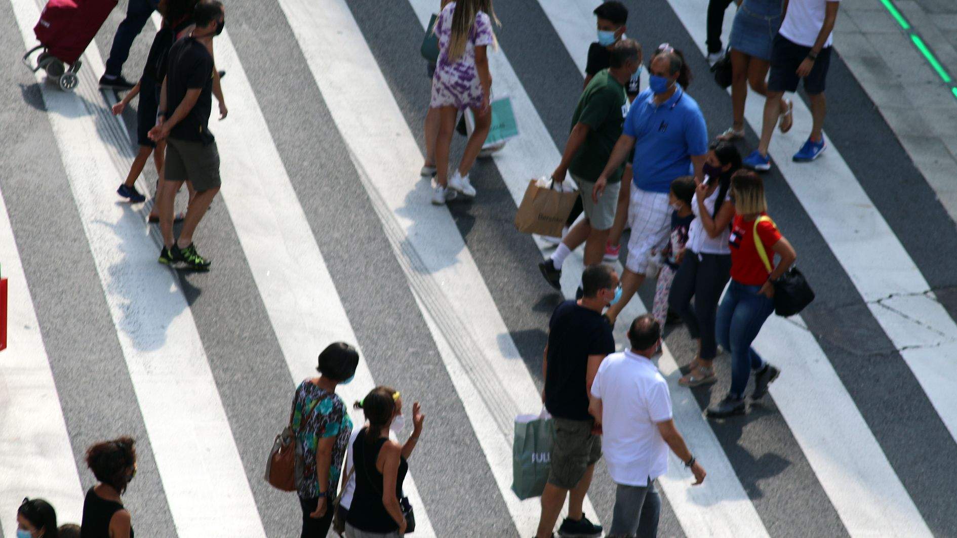 Diversos vianants creuant un pas al centre d'Andorra la Vella aquest dissabte.