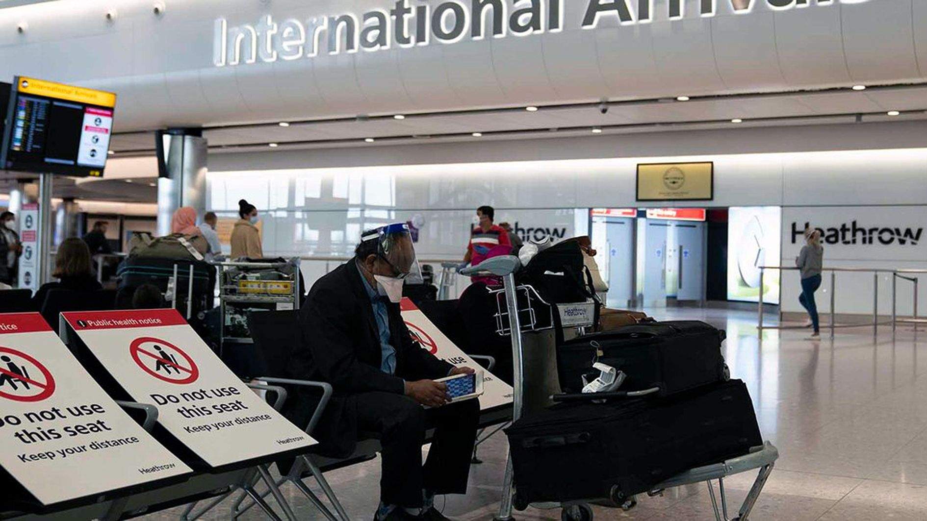 Un passatger esperant per embarcar a l'aeroport internacional de Heathrow.