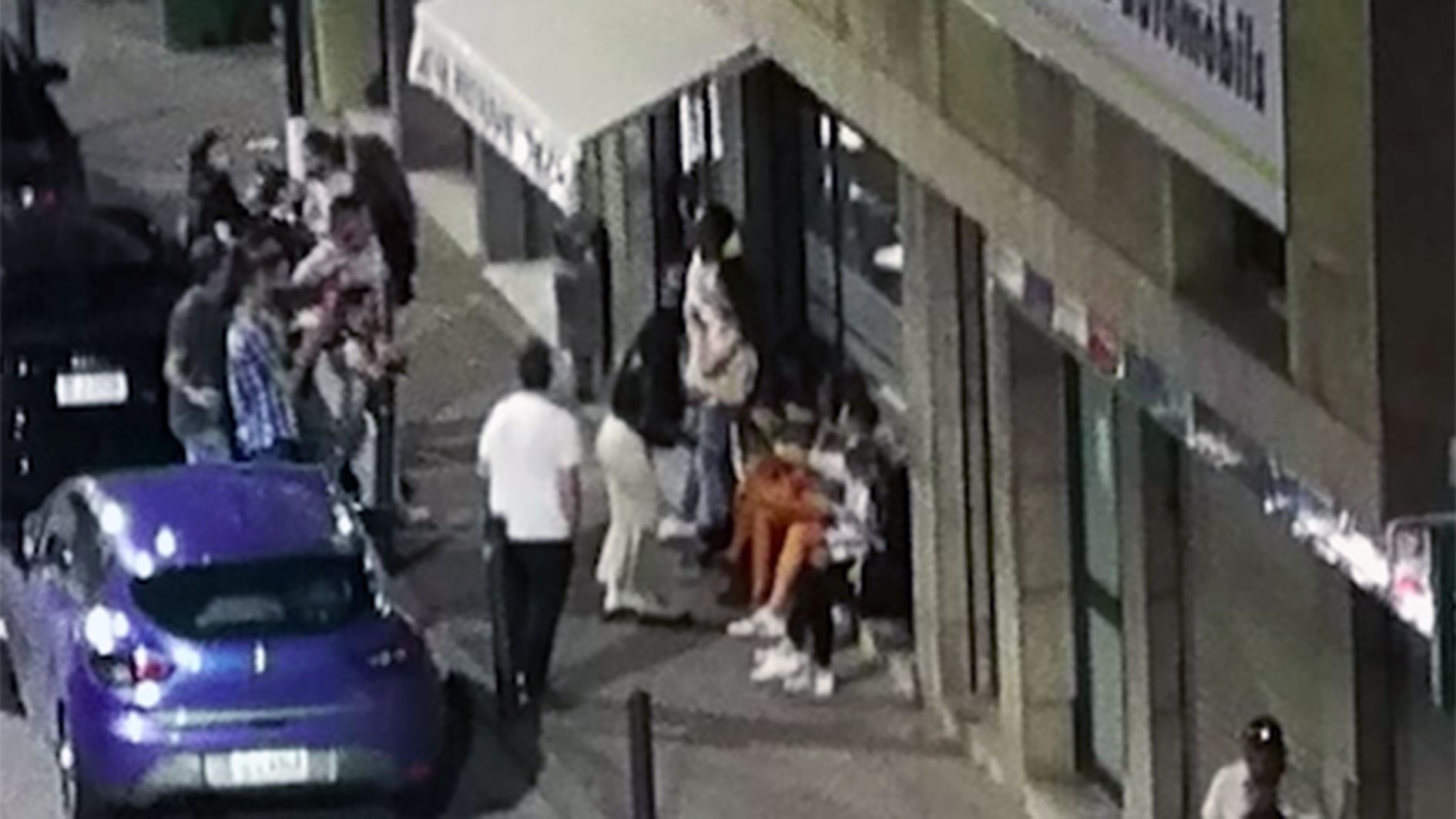 Joves a la porta d'un establiment formalment tancat a l'avinguda Santa Coloma aquesta passada matinada.