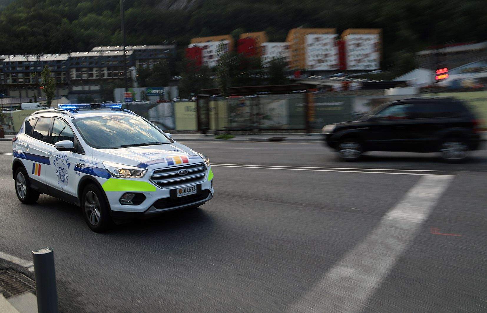 Un cotxe de policia dirigint-se cap a la Seu de la Justícia.