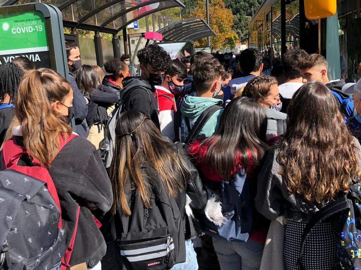 Estudiants intentant agafar un dels (pocs) busos que ha passat per la parada.