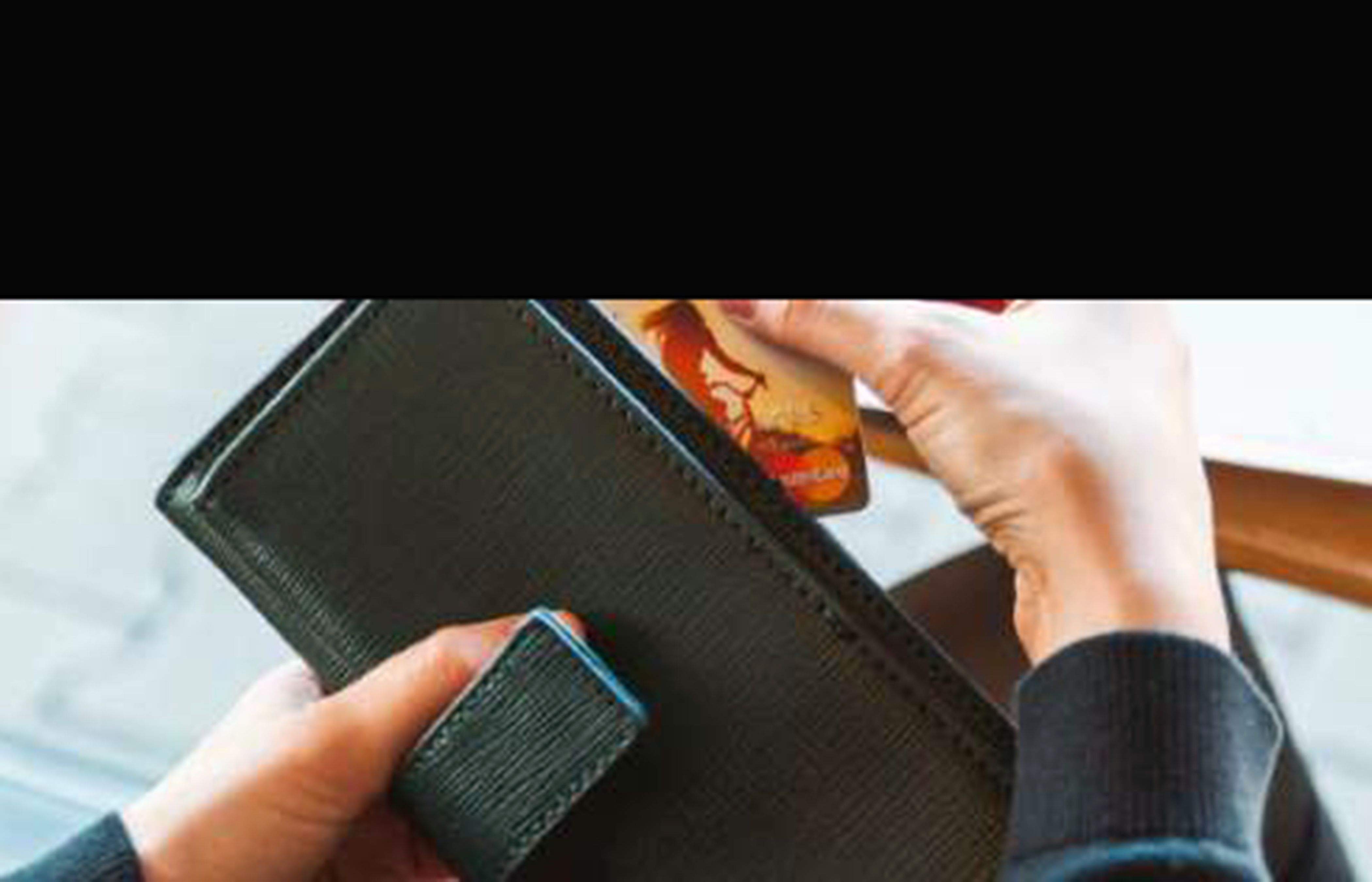 Sostraient una targeta d'una cartera.