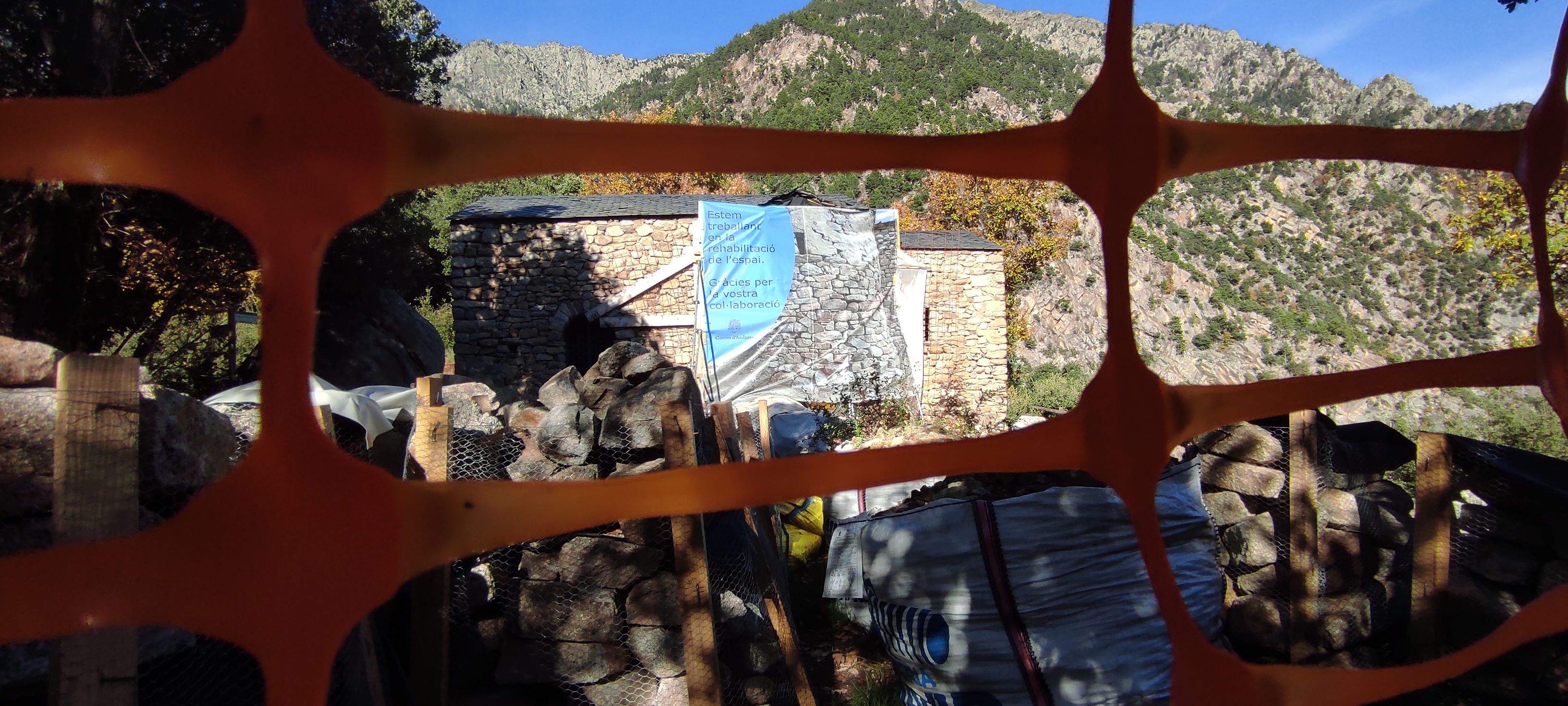 Sant Vicenç sense campanar a través d'una de les malles que encercla el recinte.