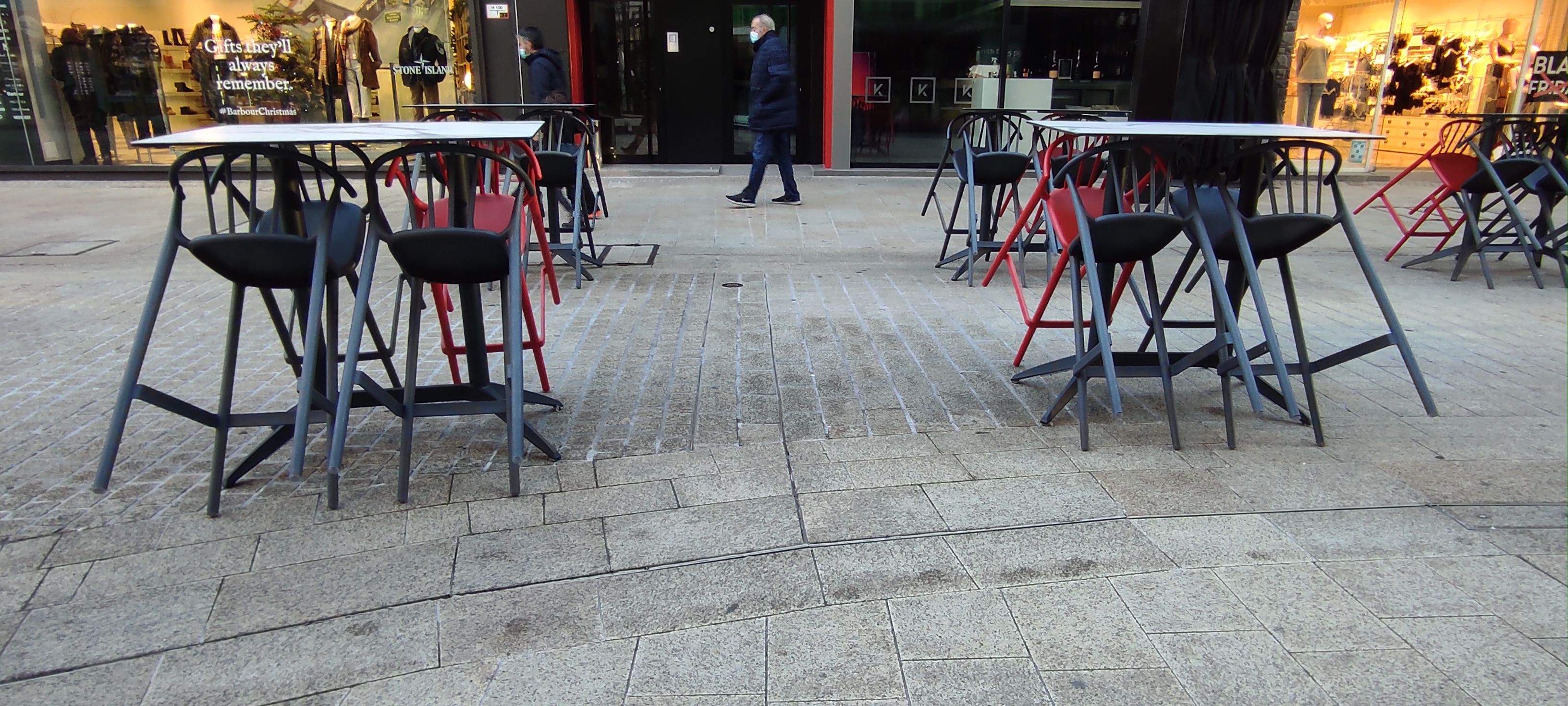Taules i cadires a la terrassa d'un bar.