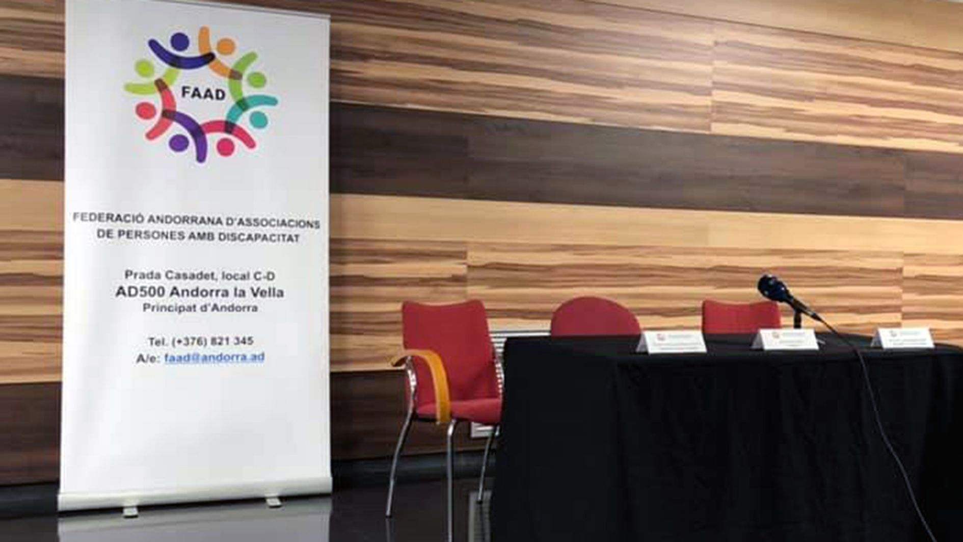 Cartell de la FAAD en una sala abans d'un acte.