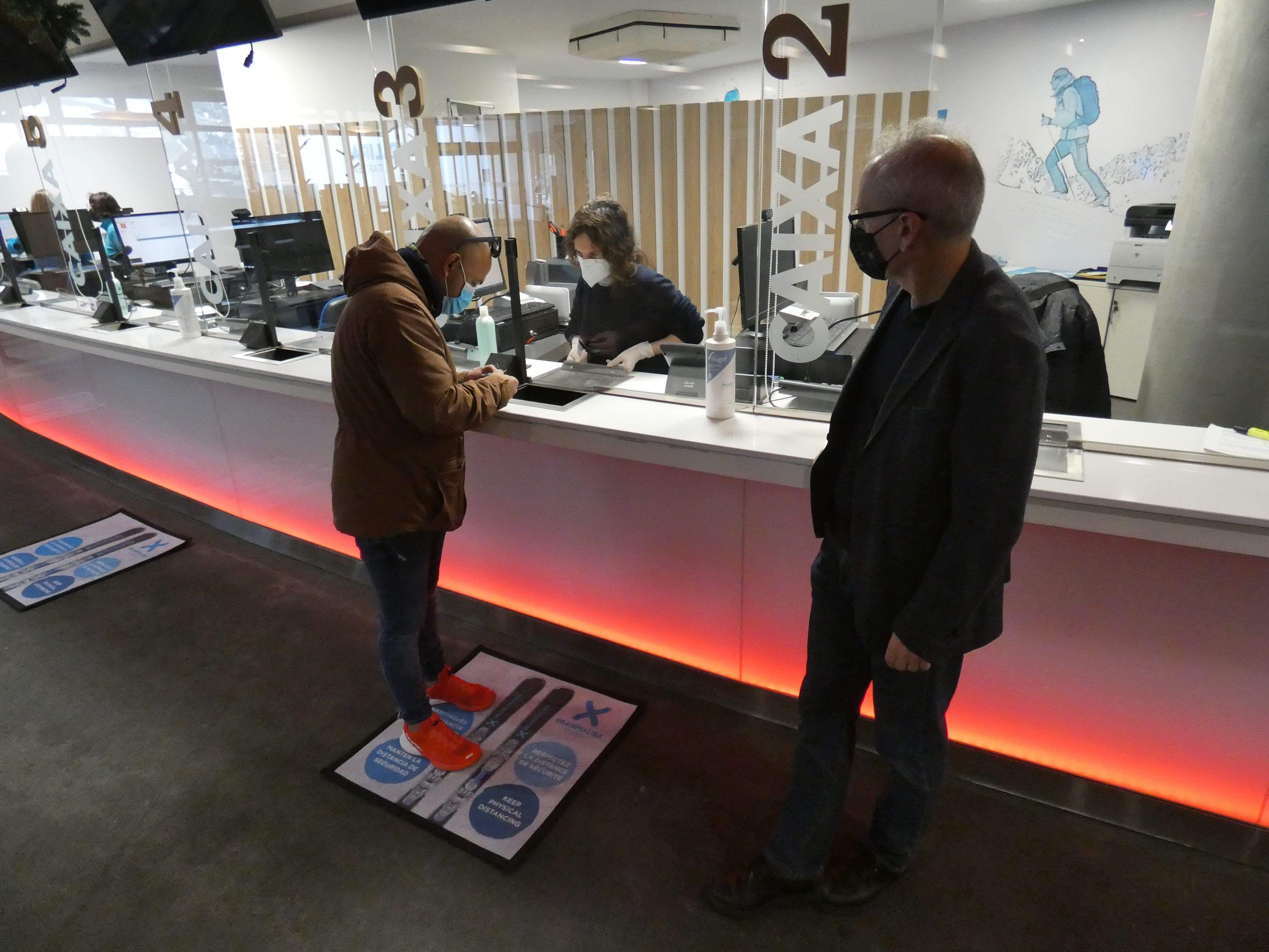 Un ciutadà canillenc recollint el test en les instal·lacions del telecabina del Tarter sota l'atenta mirada del cònsol.