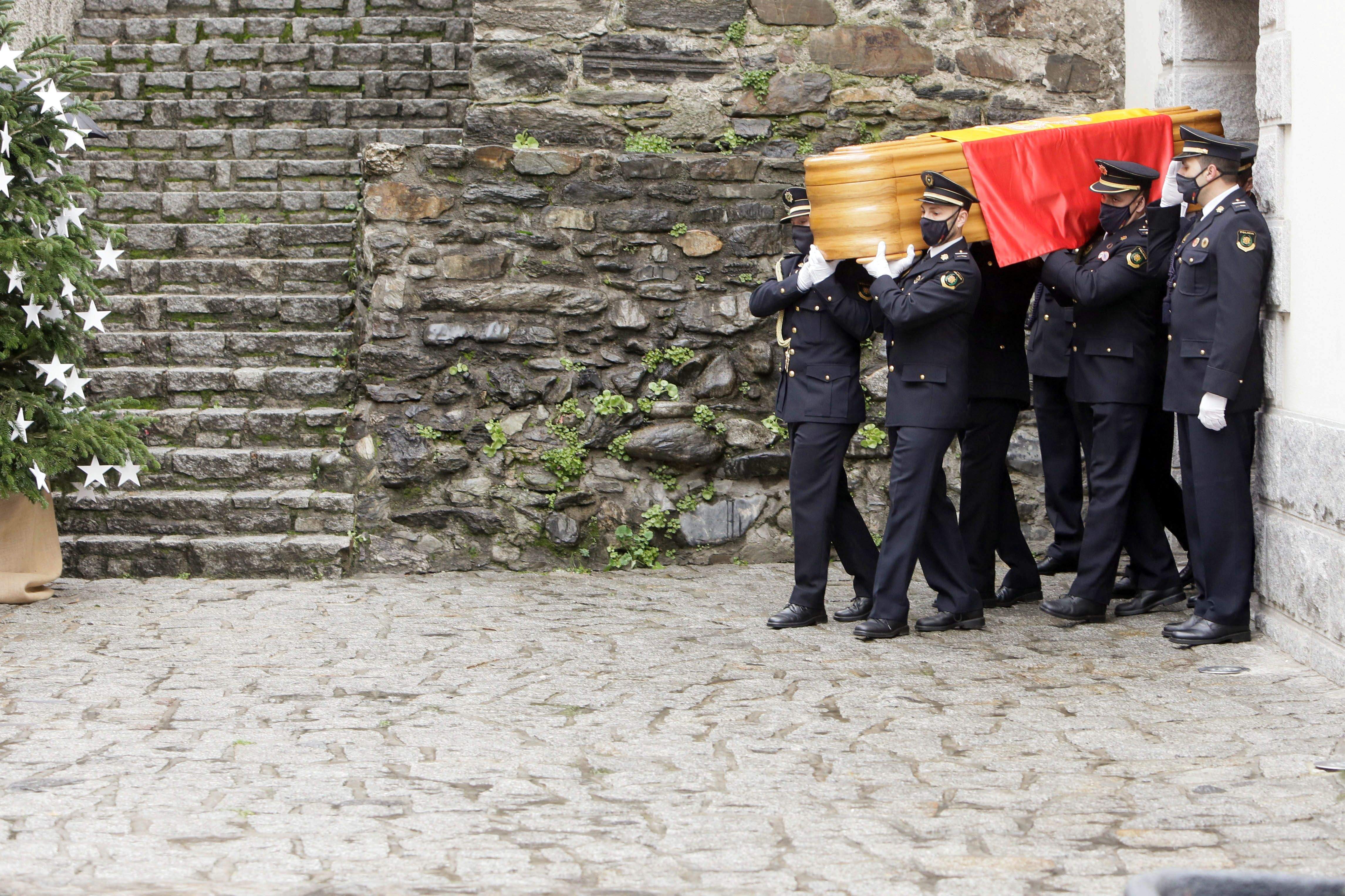Agents de policia treuen a l'espatlla el fèretre de l'església on s'ha celebrat el funeral.