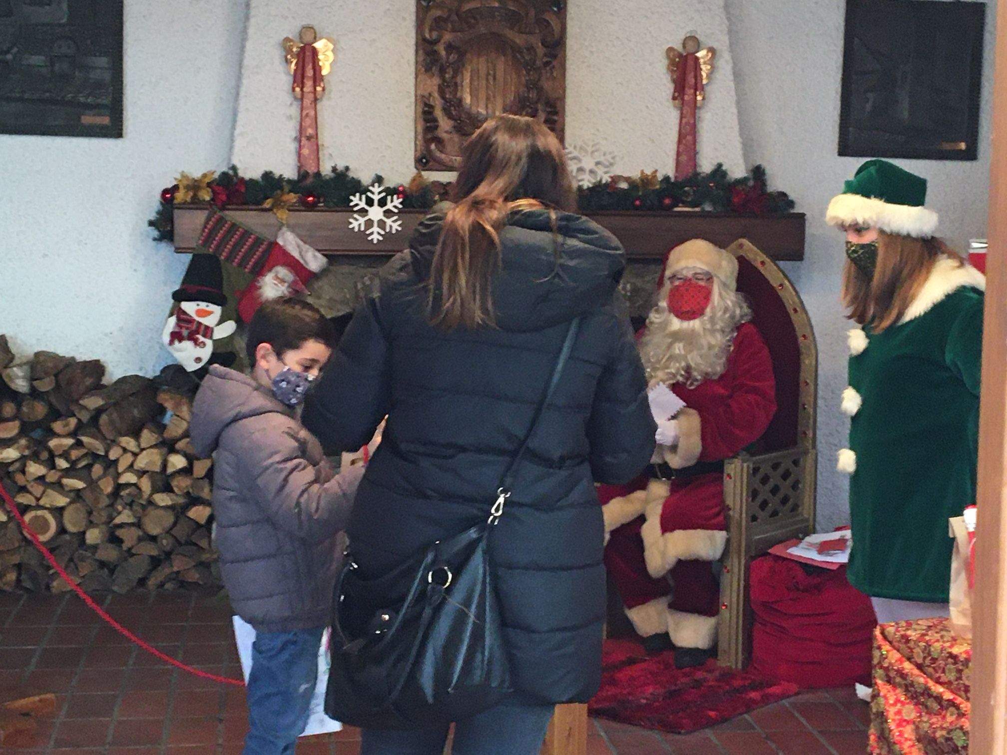 Un nen amb la seva mare es disposa a lliurar la carta al Pare Noel.