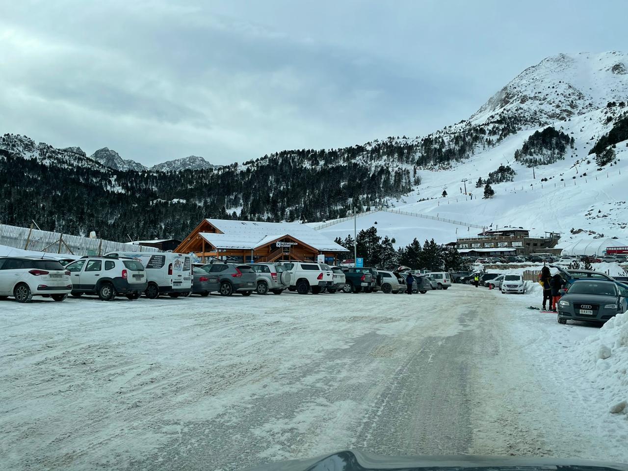 Cotxes aparcats a un estacionament de pistes.