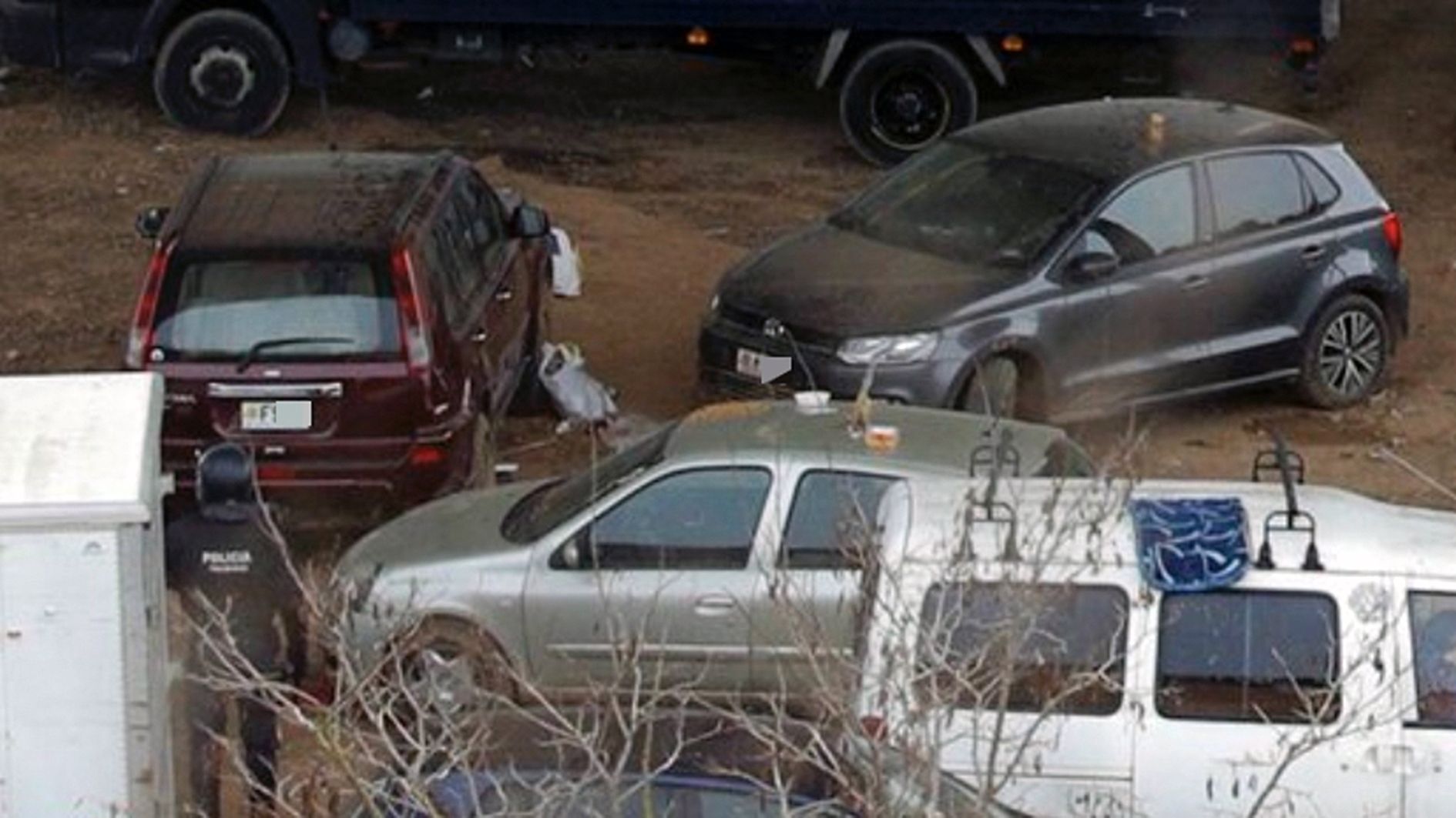 Un mosso a tocar de dos cotxes andorrans (el de color granat i el fosc).