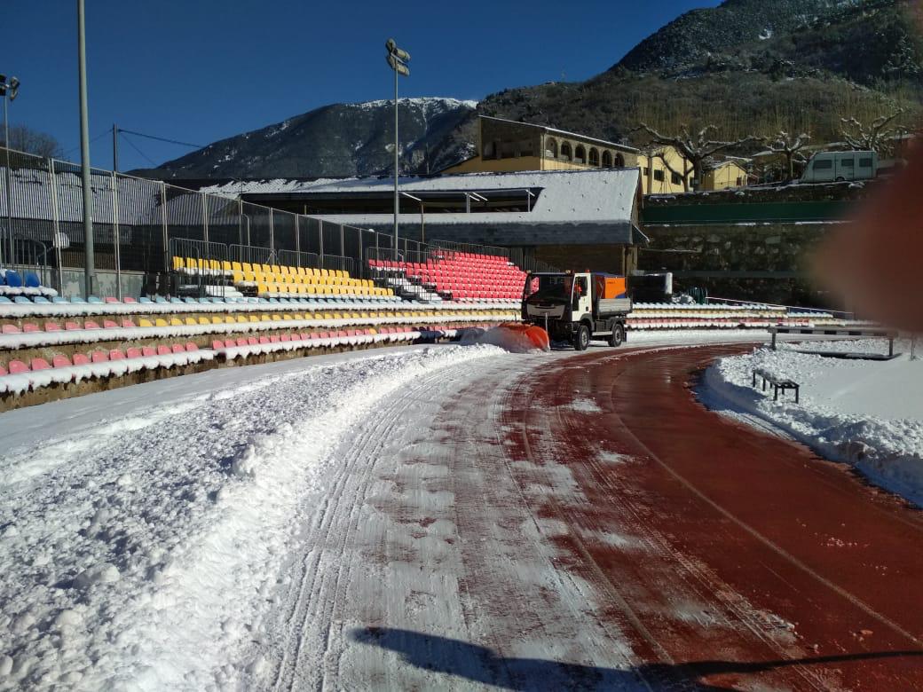 Una màquina comunal procedint a netejar la pista sintètica.