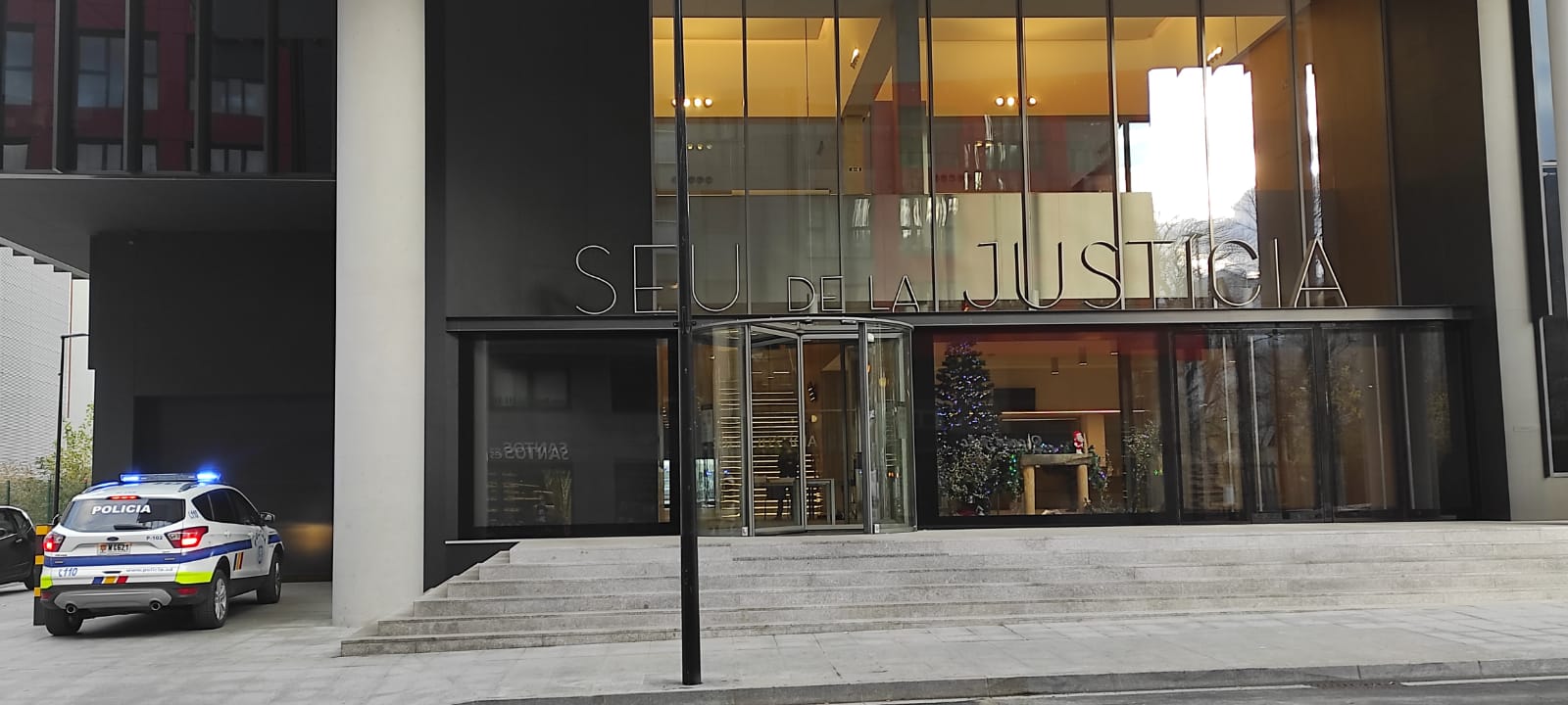 Un vehicle policial accedint a la Seu de la Justícia per traslladar-hi un detingut.