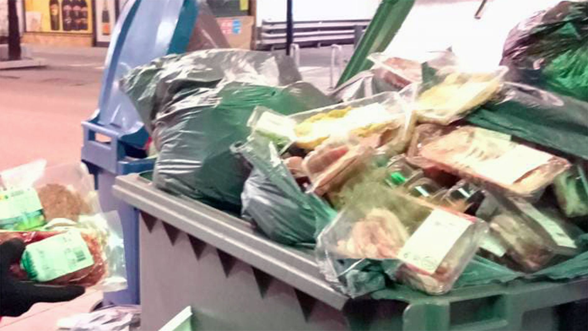 Productes fresos dipositats en un contenidor just davant d'un cèntric hipermercat d'Andorra la Vella.