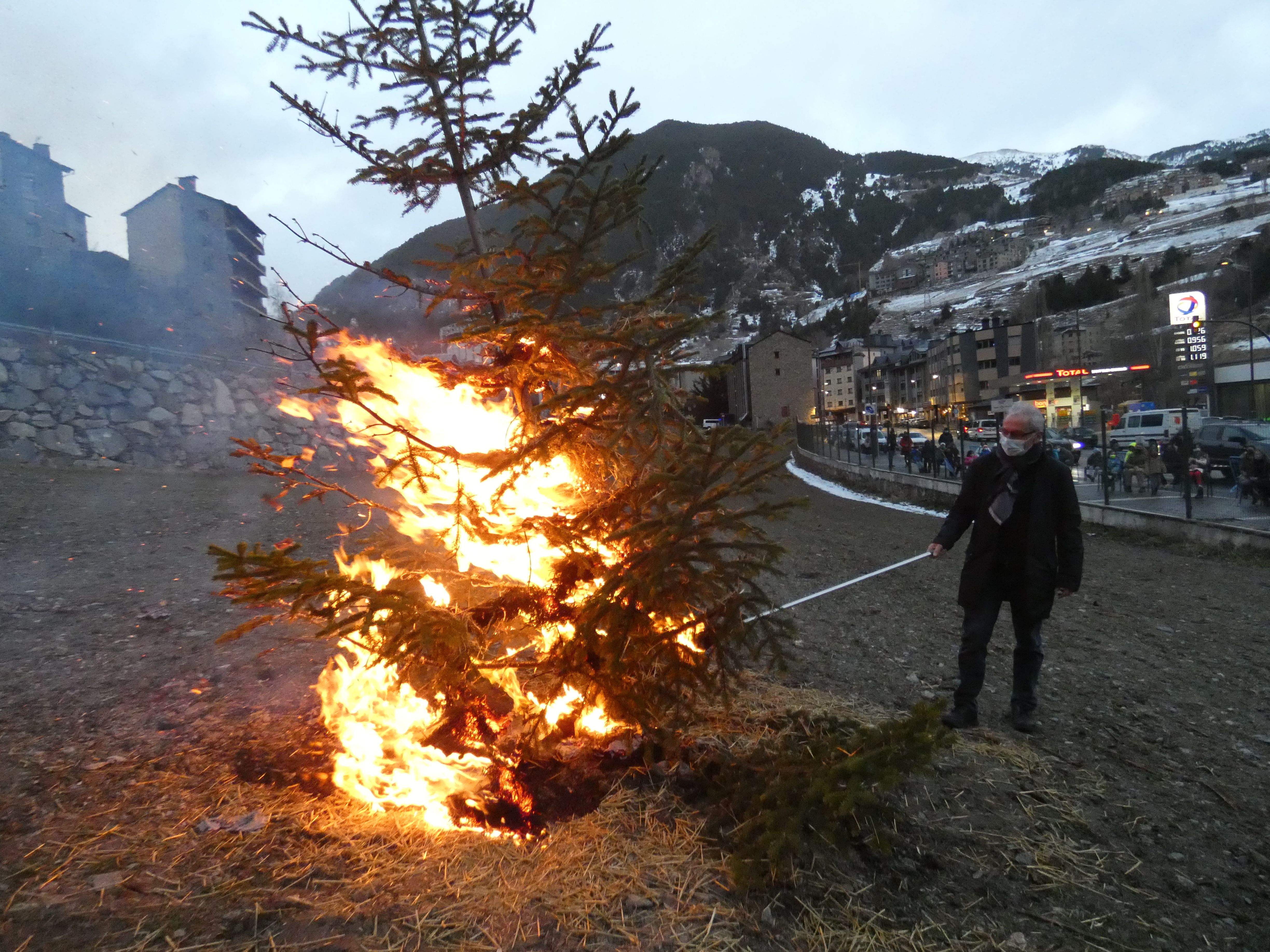 El cònsol Francesc Camp cremant l'arbre amb la gent seguint l'acte rere la tanca que delimita el camp del Som.