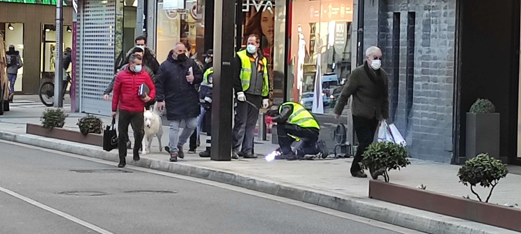 Operaris del COEX segellant una tapa del clavegueram amb un bufador a l'avinguda Meritxell.
