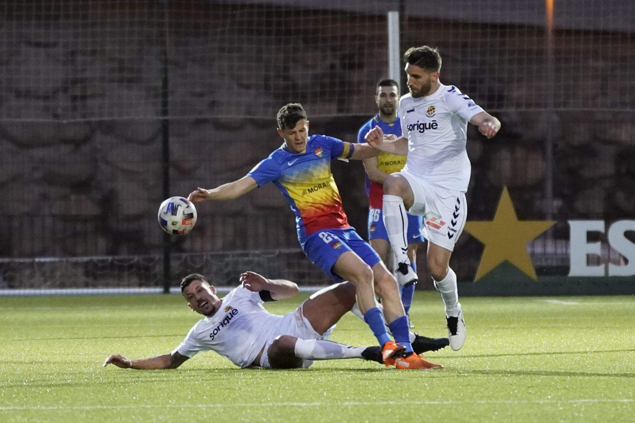 Bover, entrat per un jugador grana, a punt de caure a terra.