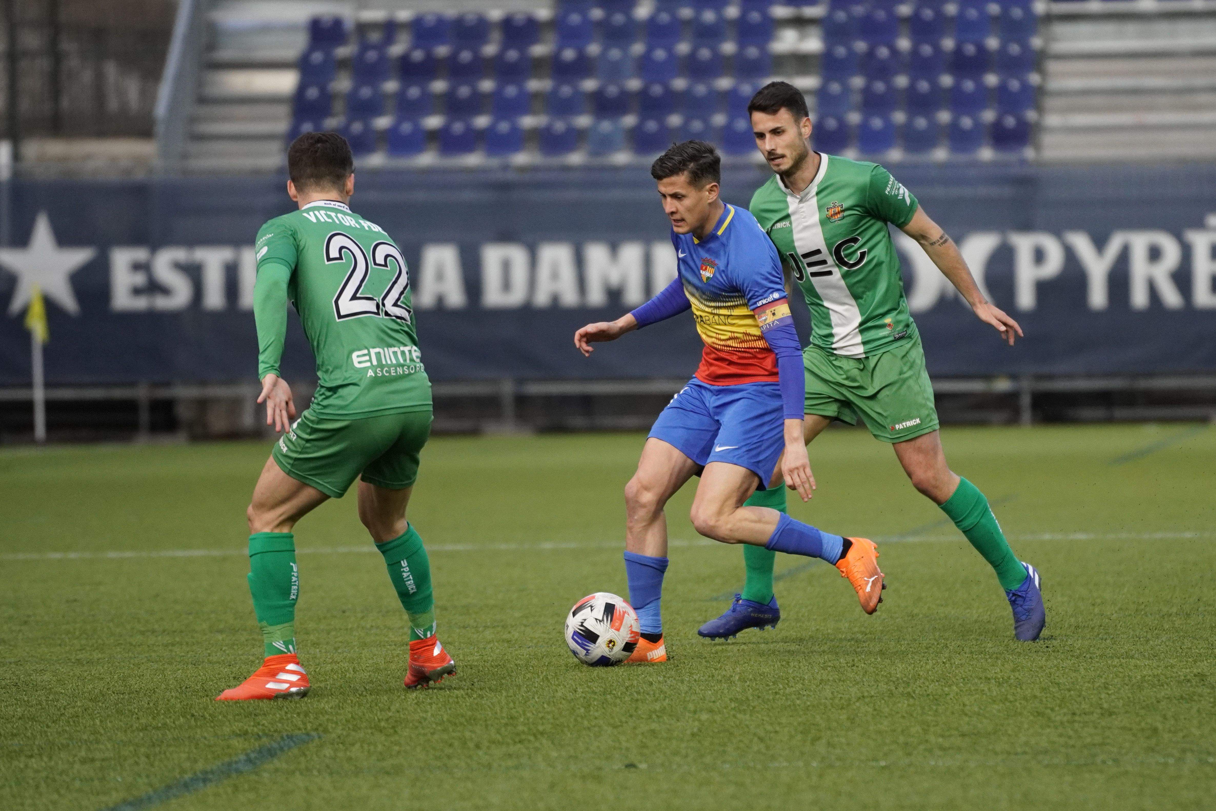 Bover intenta superar dos rivals del Cornellà.