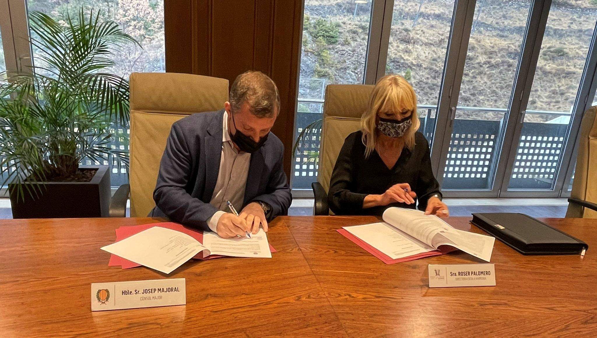Josep Majoral i Roser Palomero signen l'acord entre el comú lauredià i l'escola Harmonia.