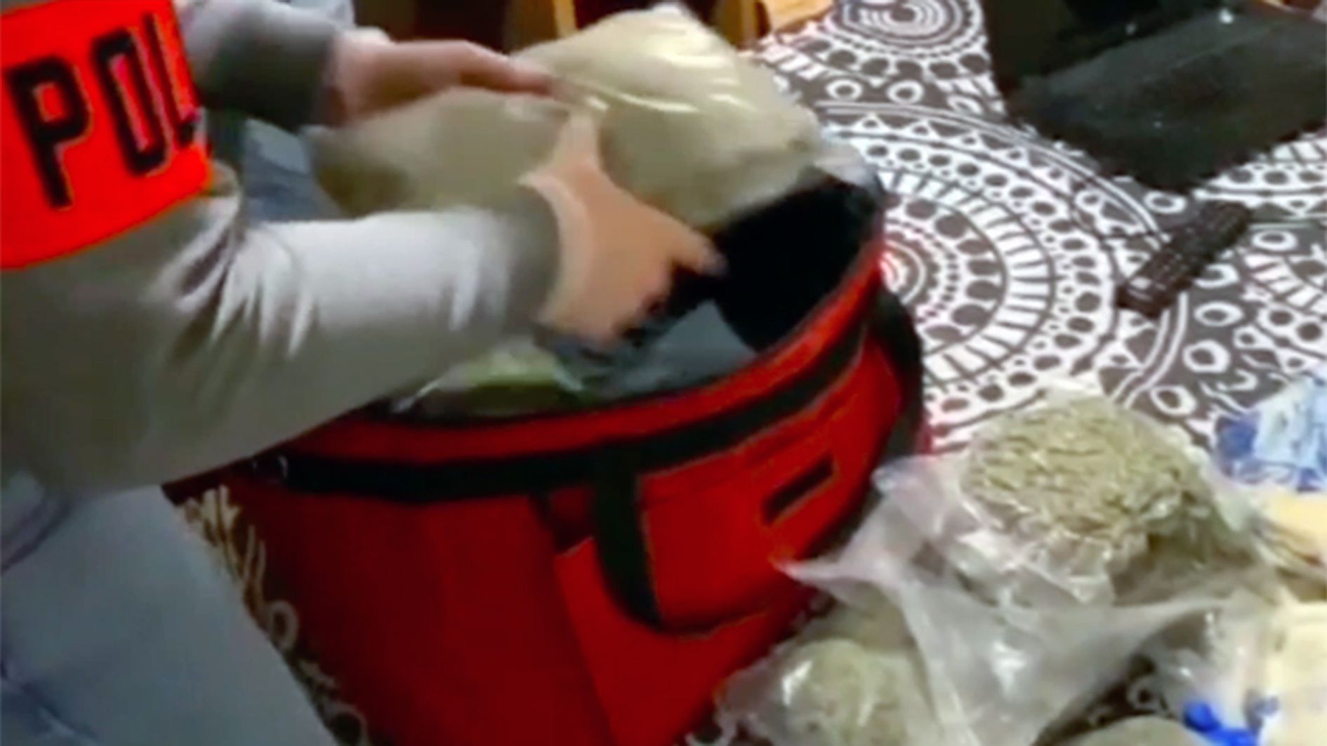 Un policia 'descarregant' una motxilla de bosses de marihuana 'a l'engròs'.