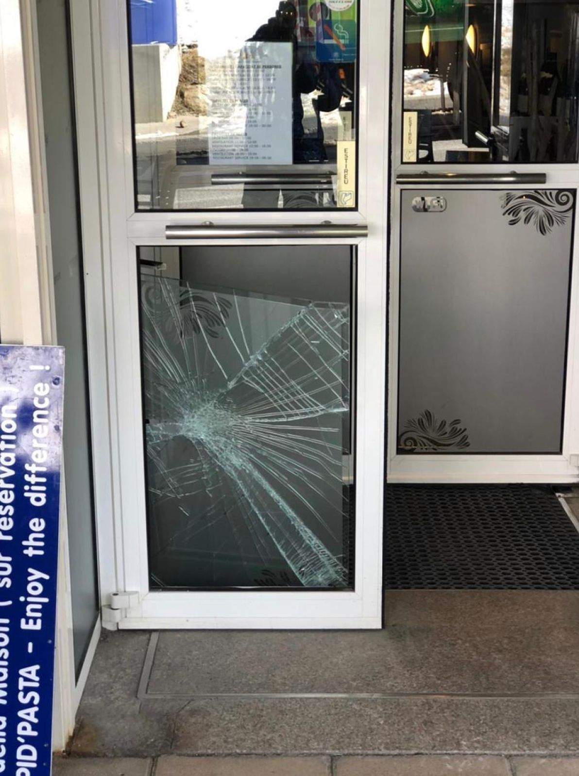 El vidre trencat d'un dels comerços afectats per la bretolada.