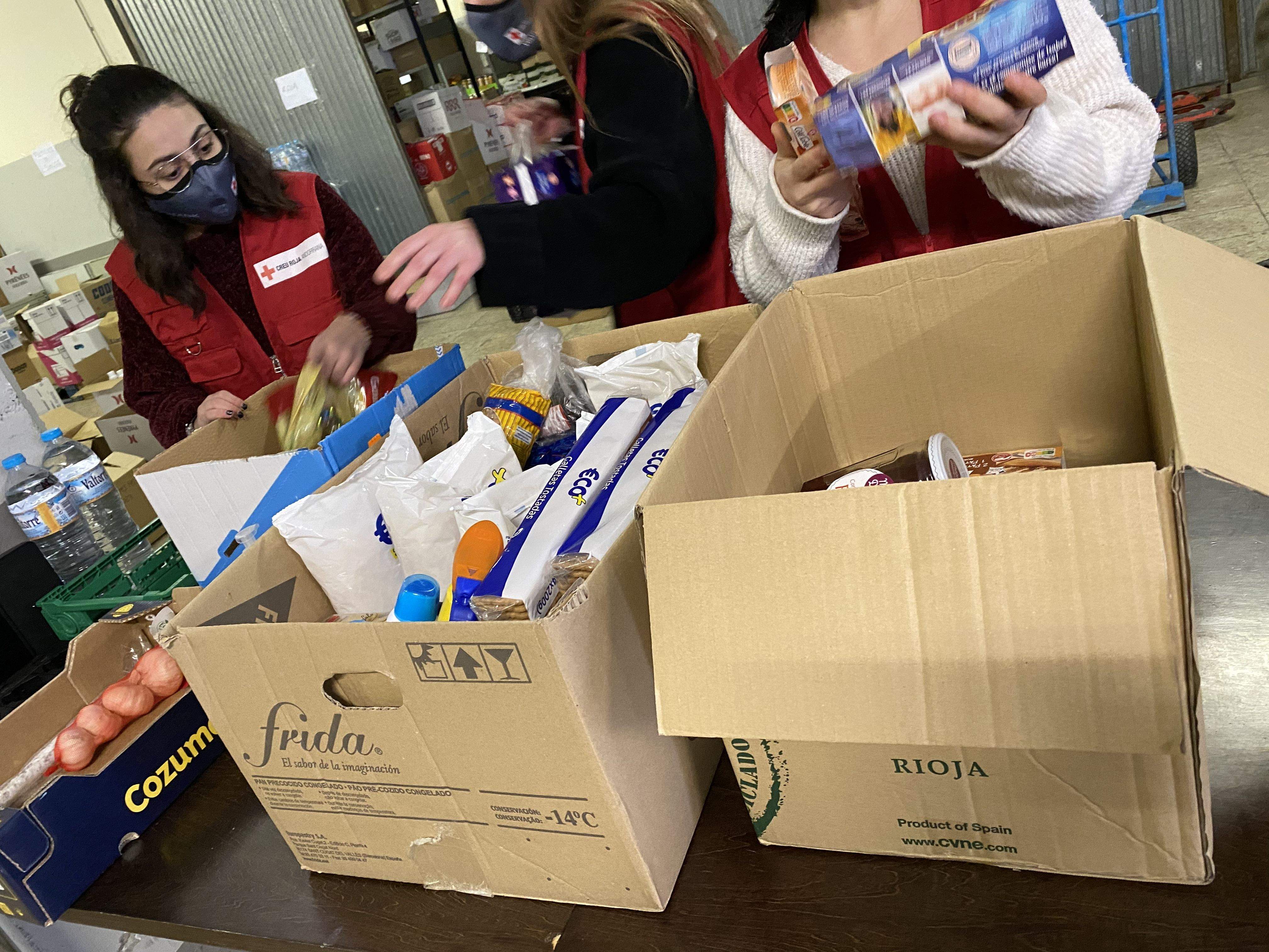 Voluntaris de Creu Roja endreçant aquest dissabte productes rebuts a la seu central.