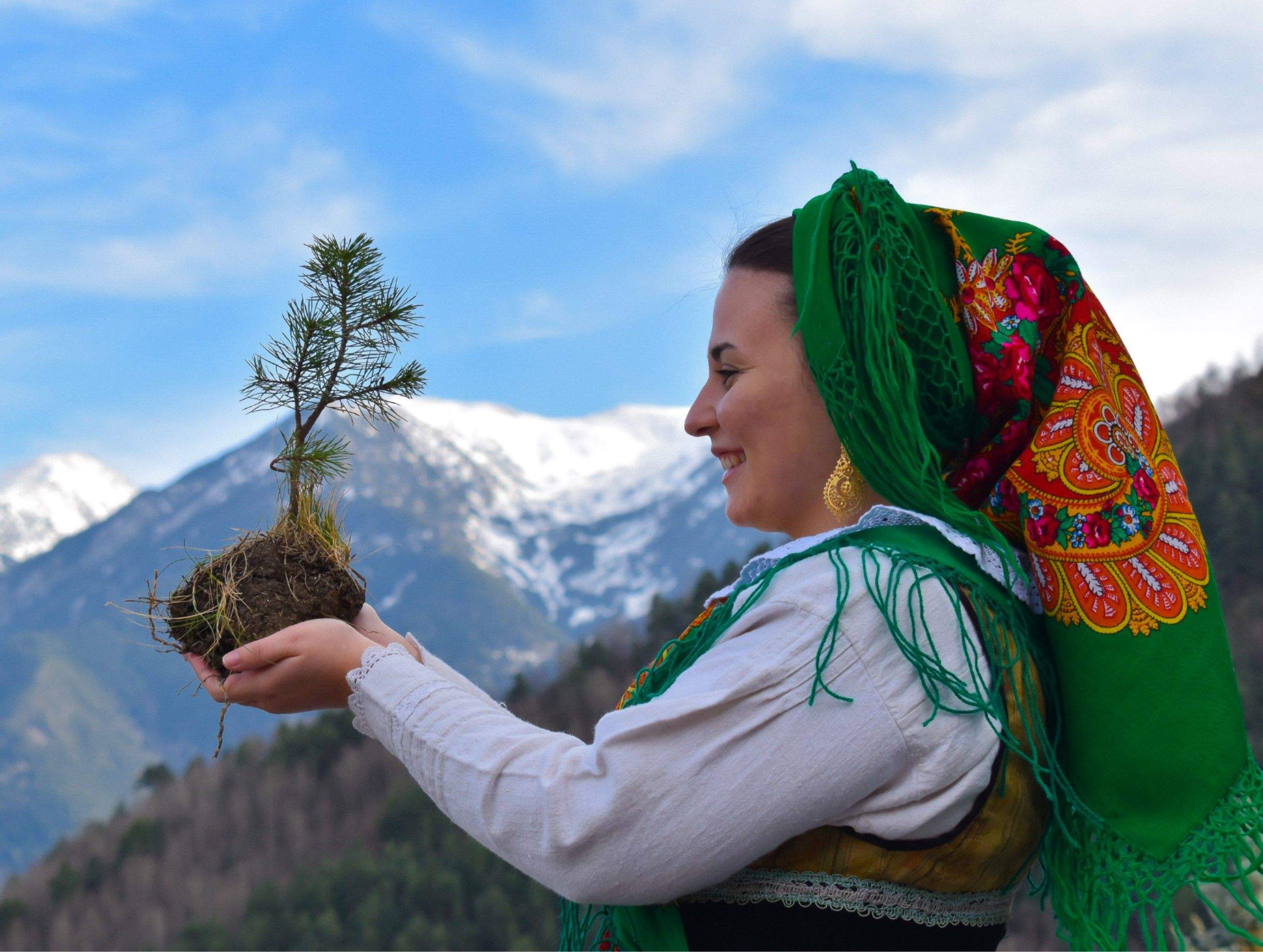 Una integrant del grup amb l'arbre que es pretén plantar.