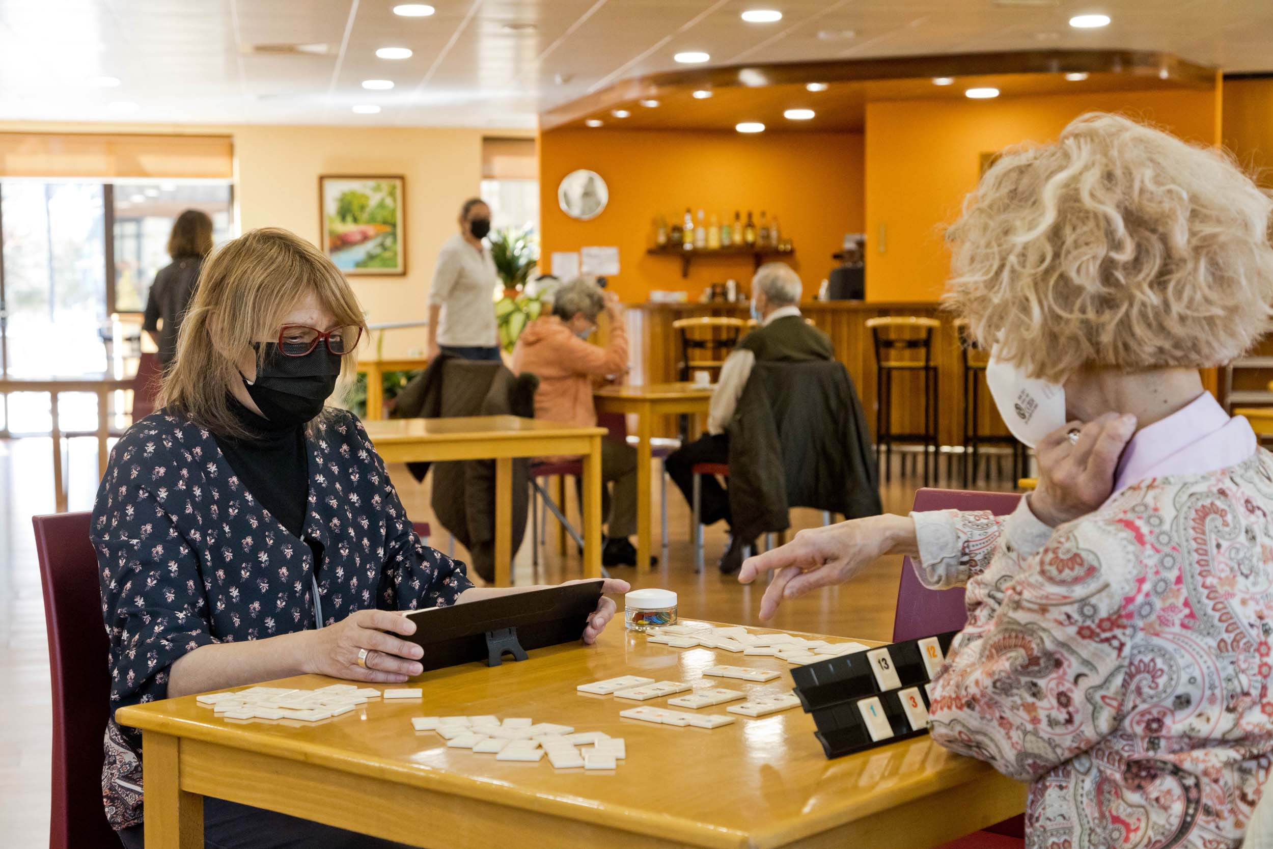 Dues padrines juguen a un joc de taula a la casa pairal de la Massana.