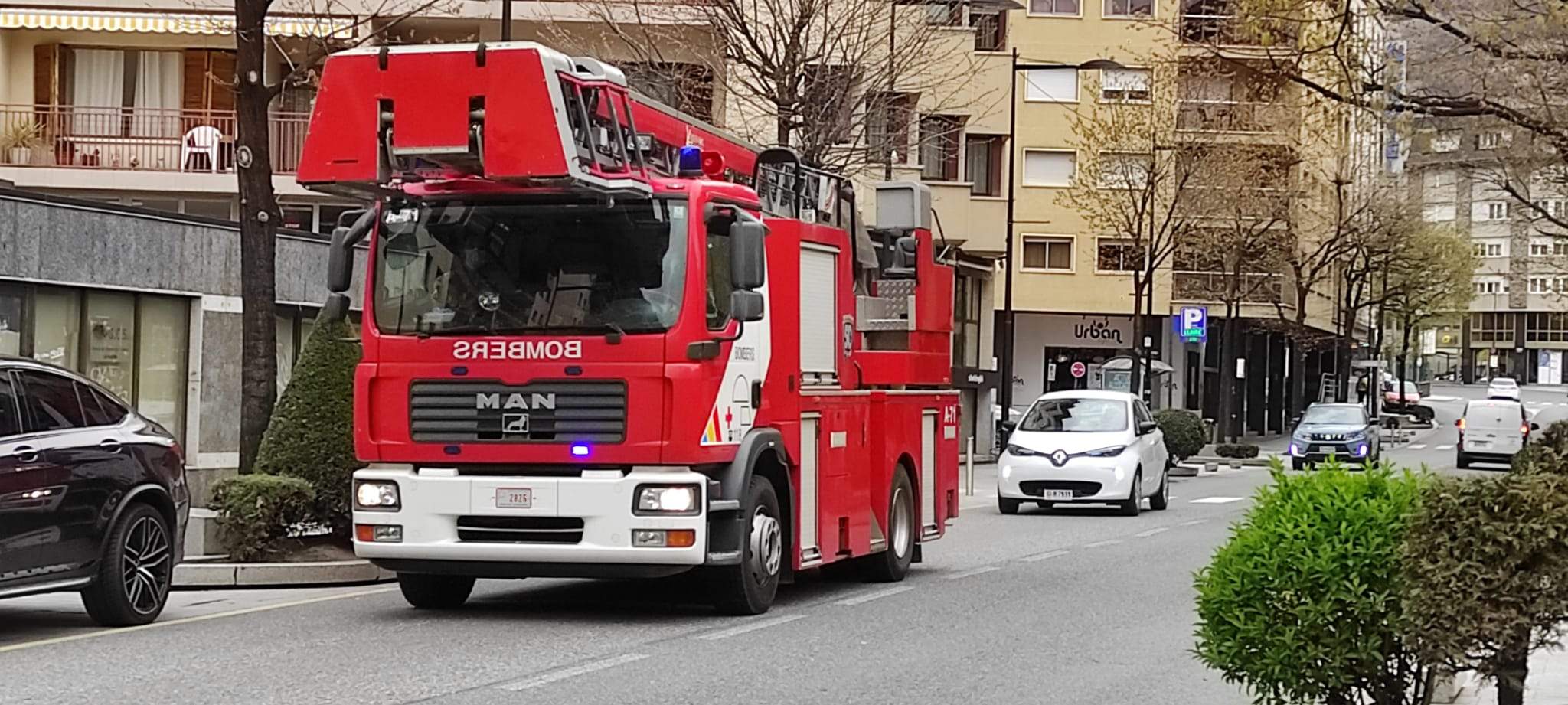 Un camió escala dels bombers tornant al parc després d'un servei.