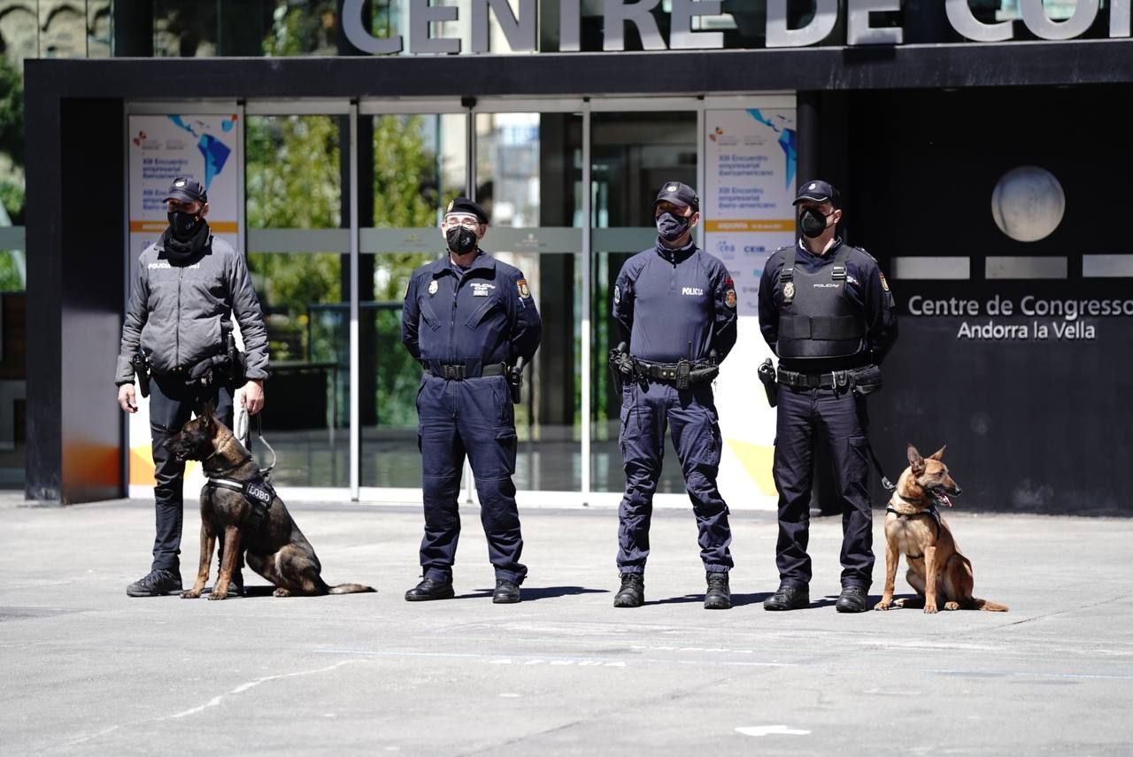 Agents de policia espanyols amb un del Principat posant davant el Centre de Congressos.