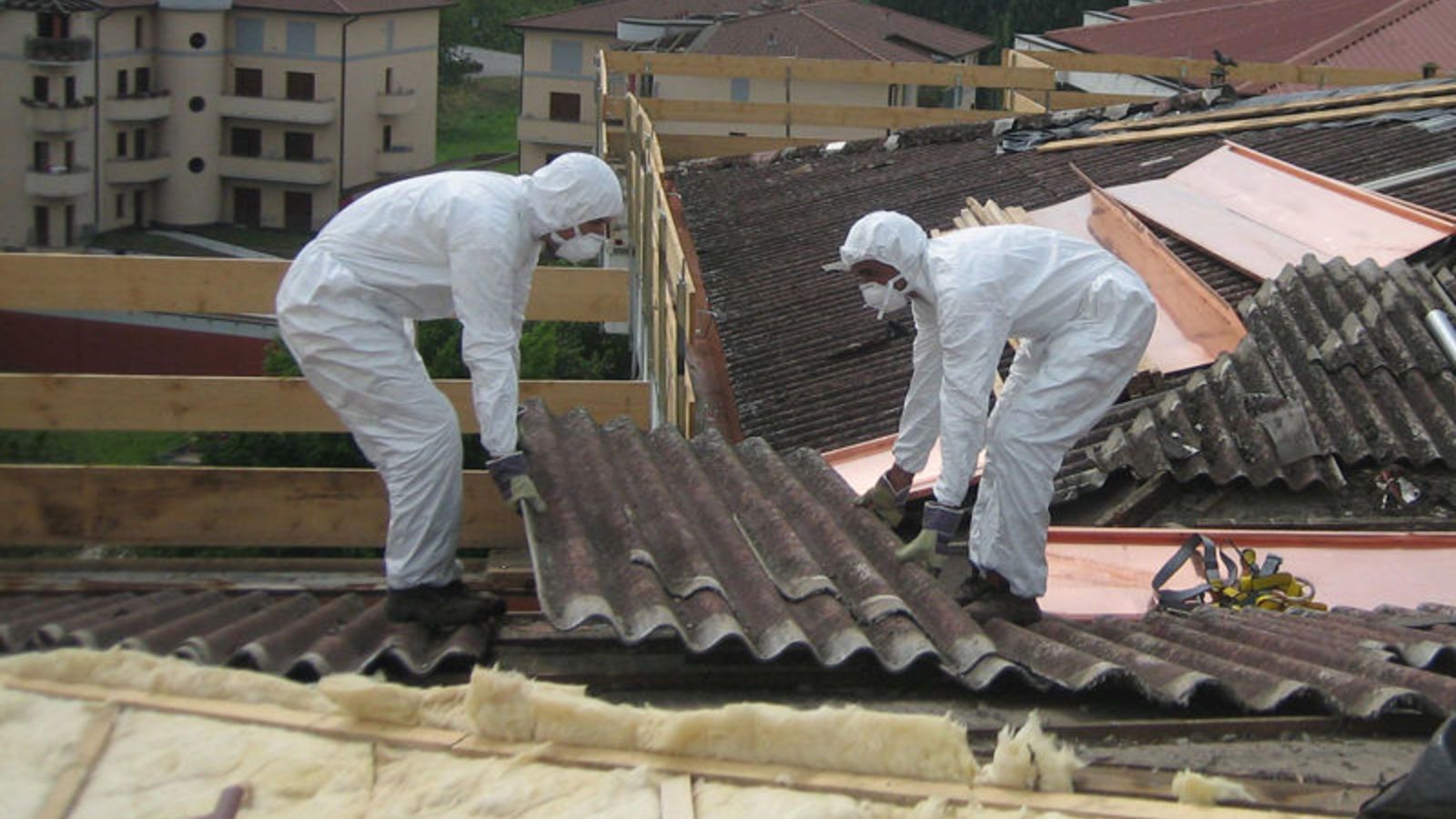 Dos operaris manipulen una peça amb amiant.