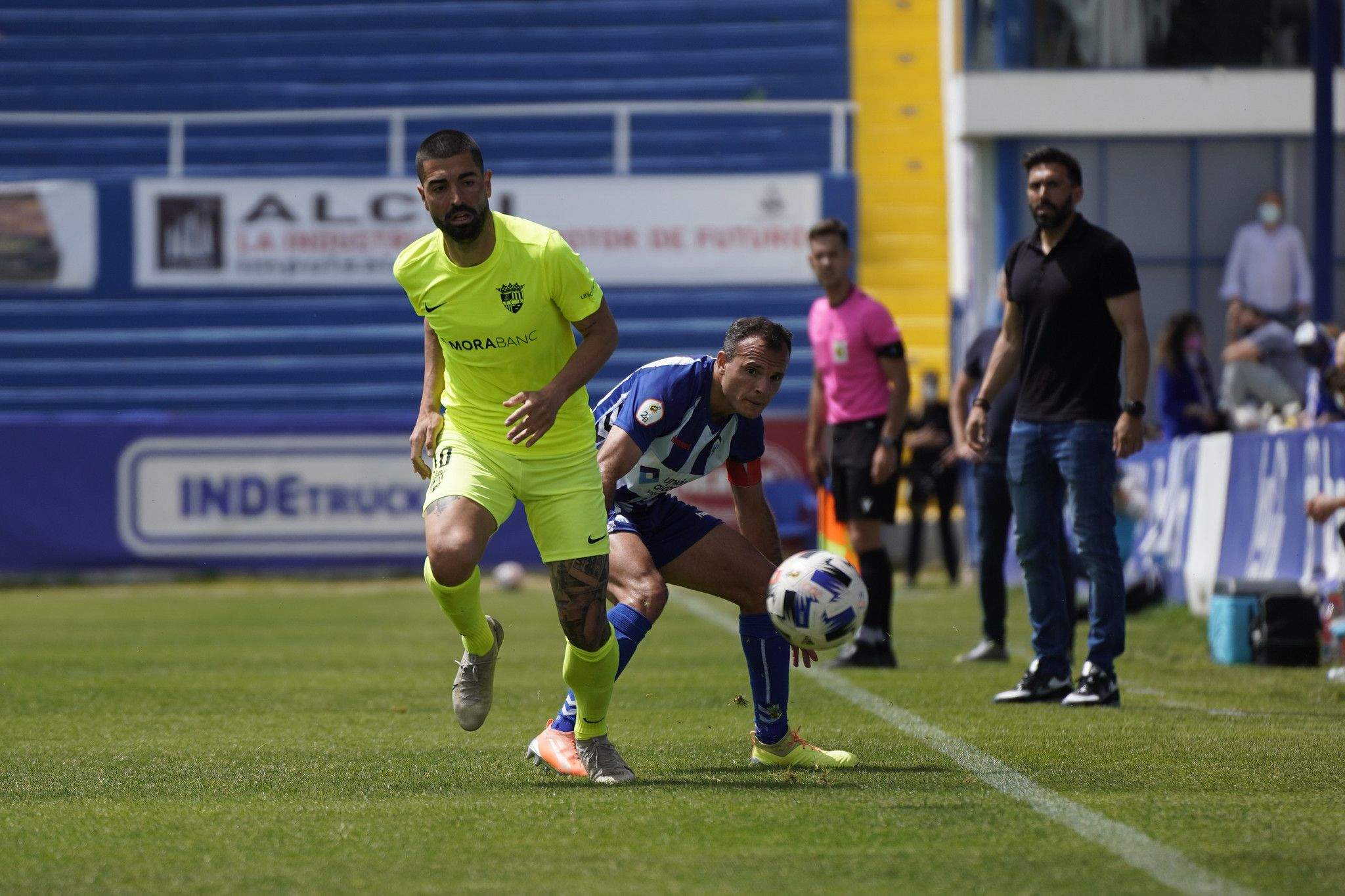 Carlos Martínez busca una pilota en un moment del partit. La portaveu del Sindicat, Rebeca Bonache.