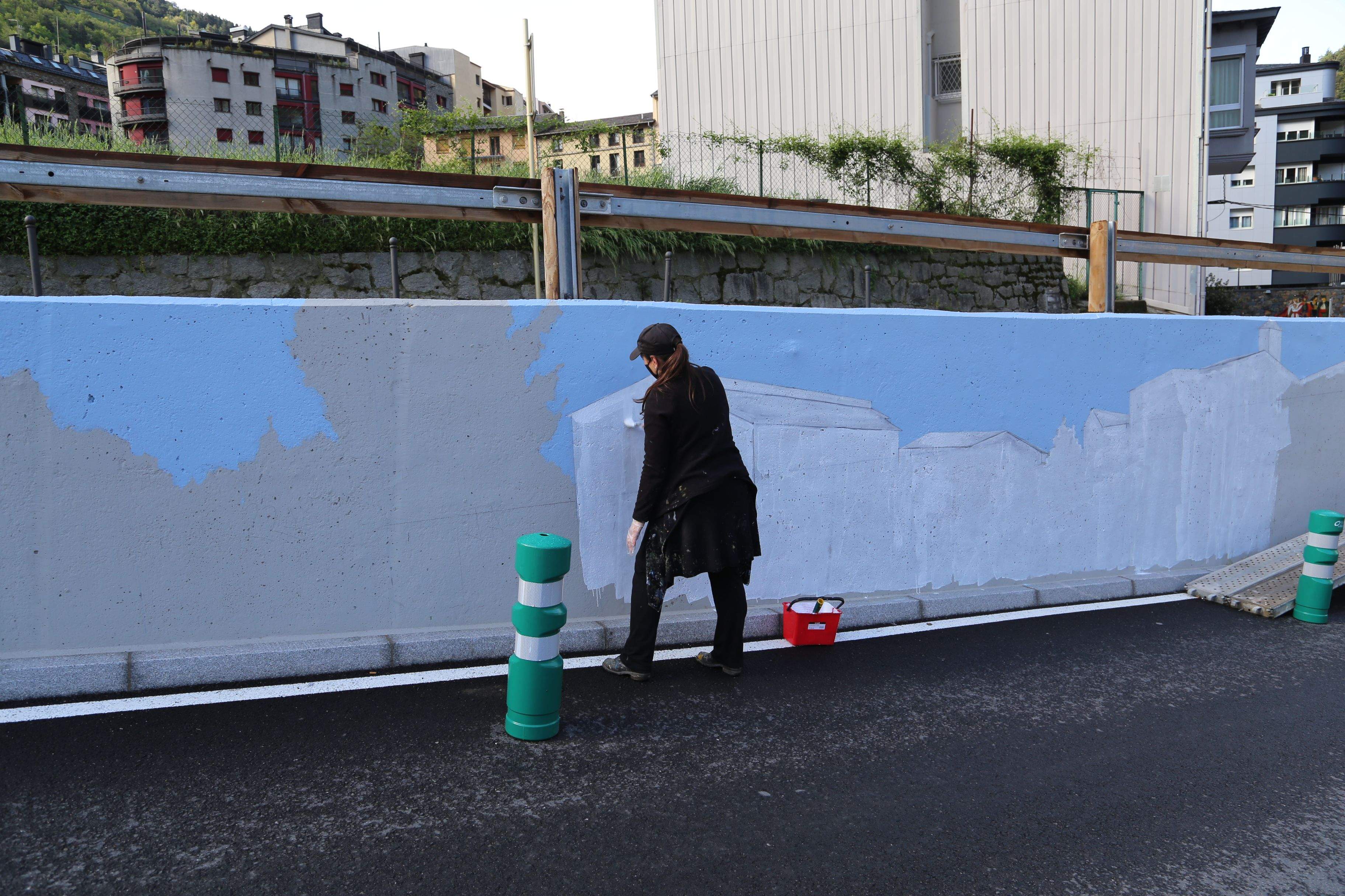 L'artista, Samantha Bosque pintant el seu mural a la carretera de Nagol.