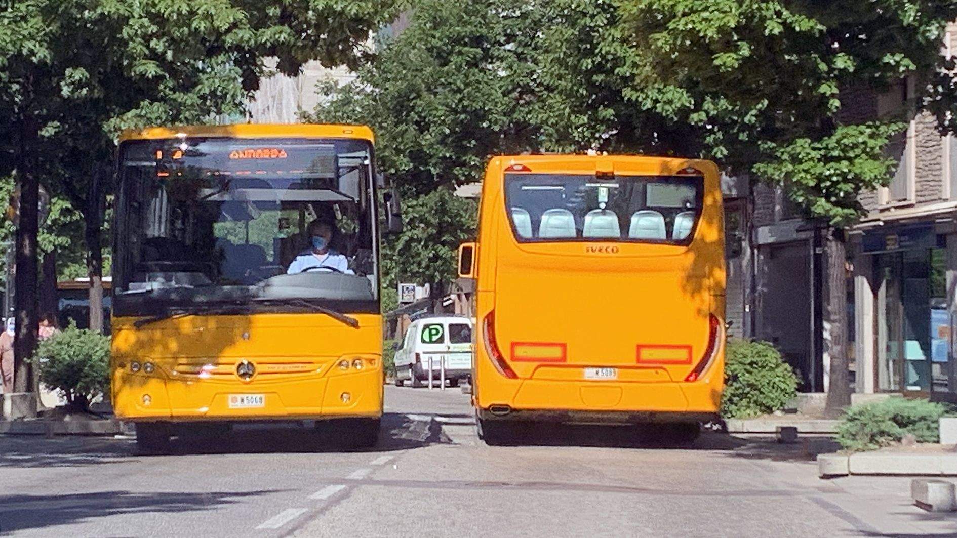 Dos busos circulant pel carrer Prat de la Creu, al centre d'Andorra la Vella.