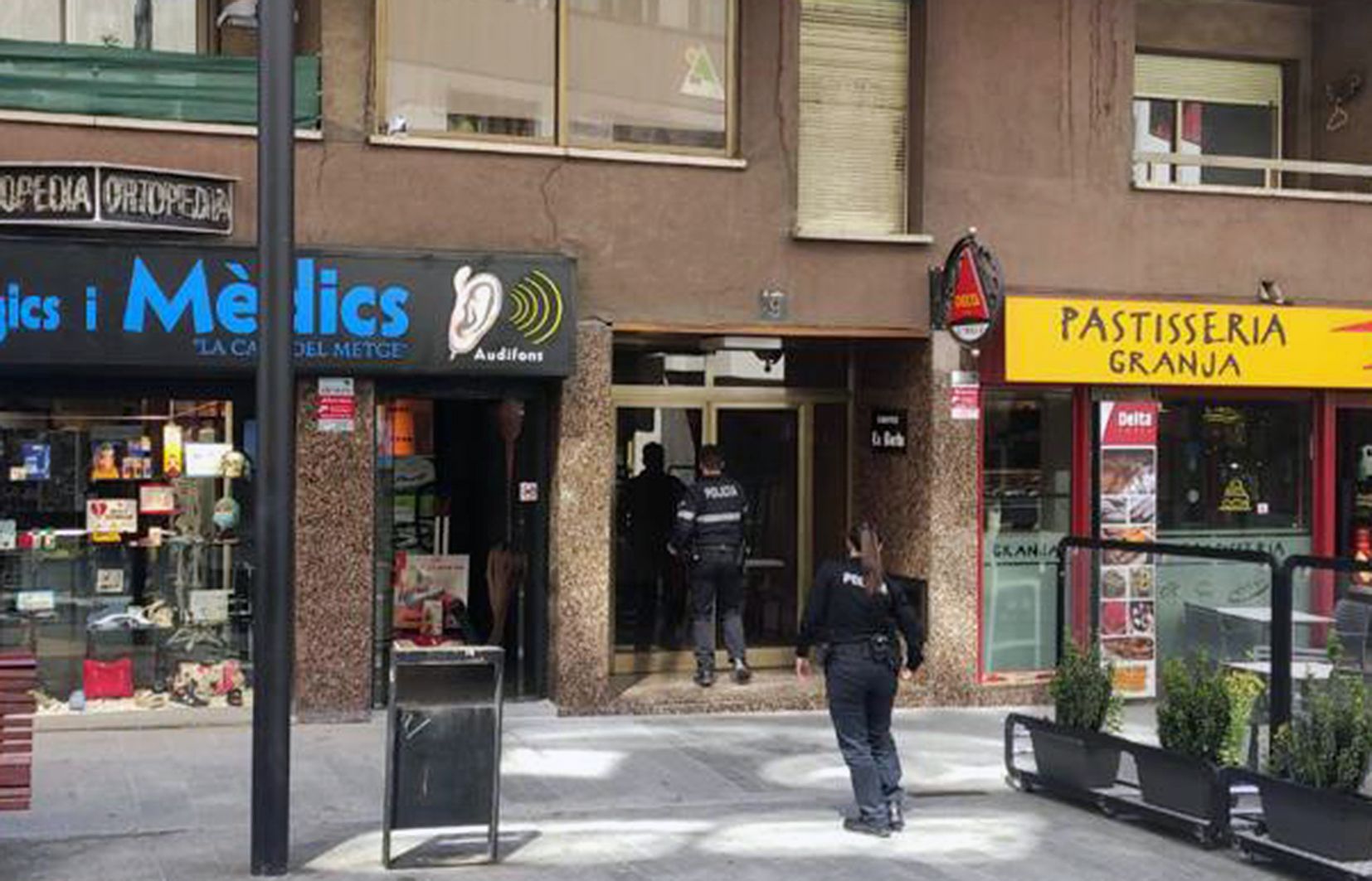 Dos agents arribant a l'edifici on hi havia instal·lada la càmera.