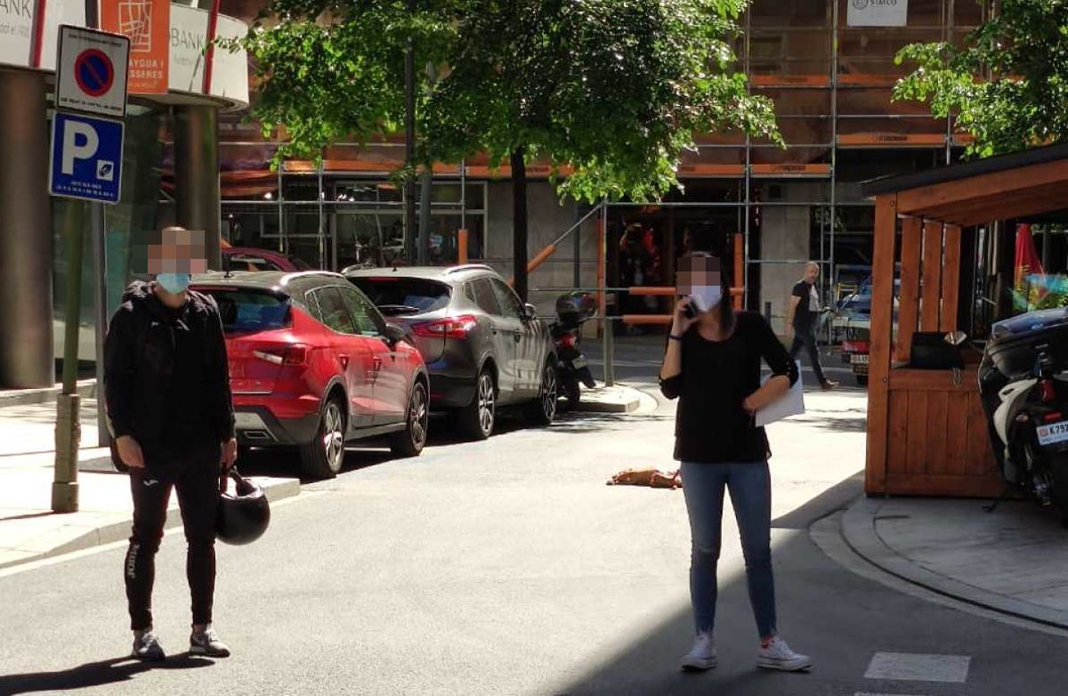 Dos vianants demanant auxili per telèfon amb la gossa al fons.