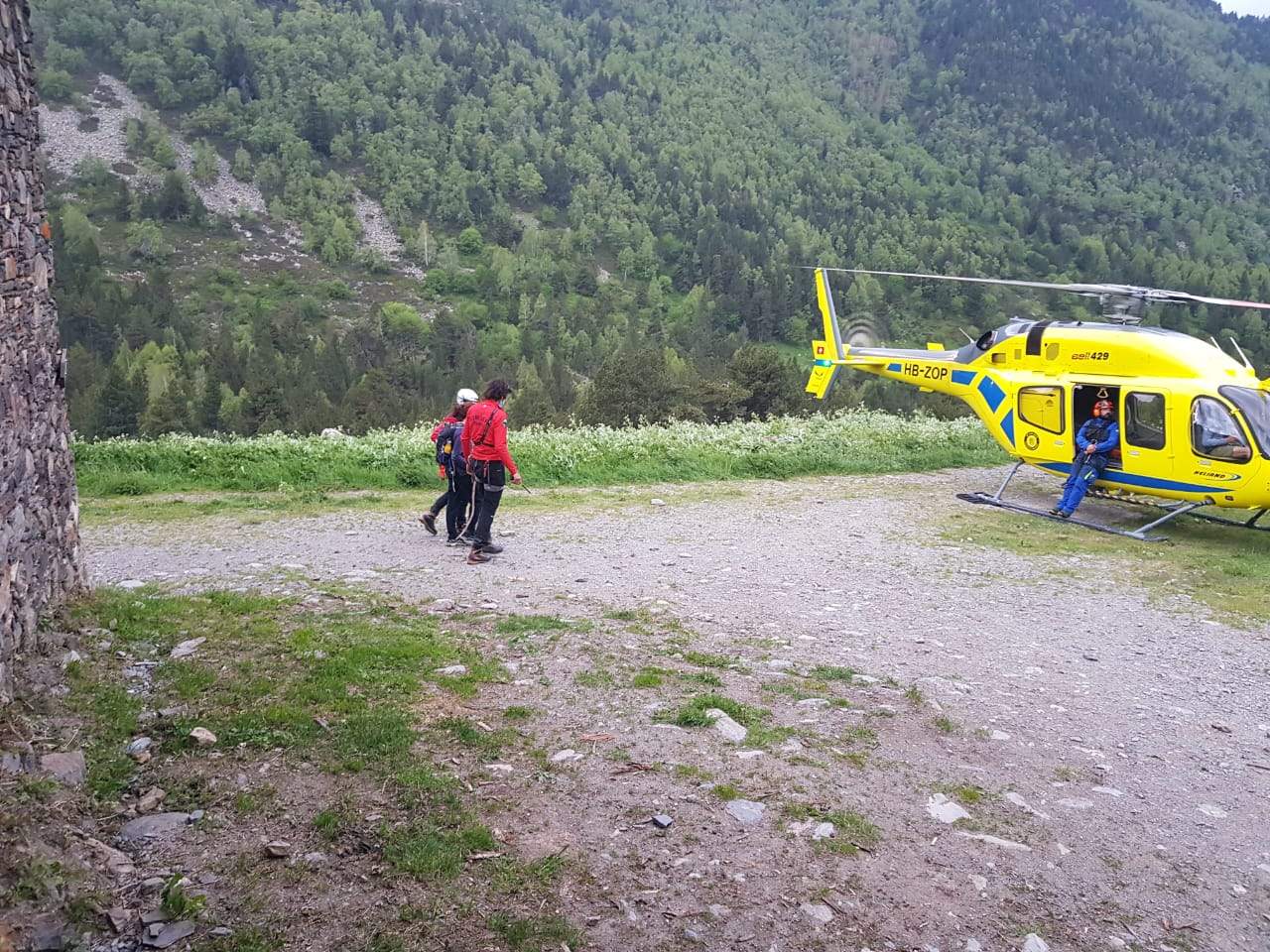 Els dos bombers acompanyen la dona cap a l'helicòpter una vegada localitzada.