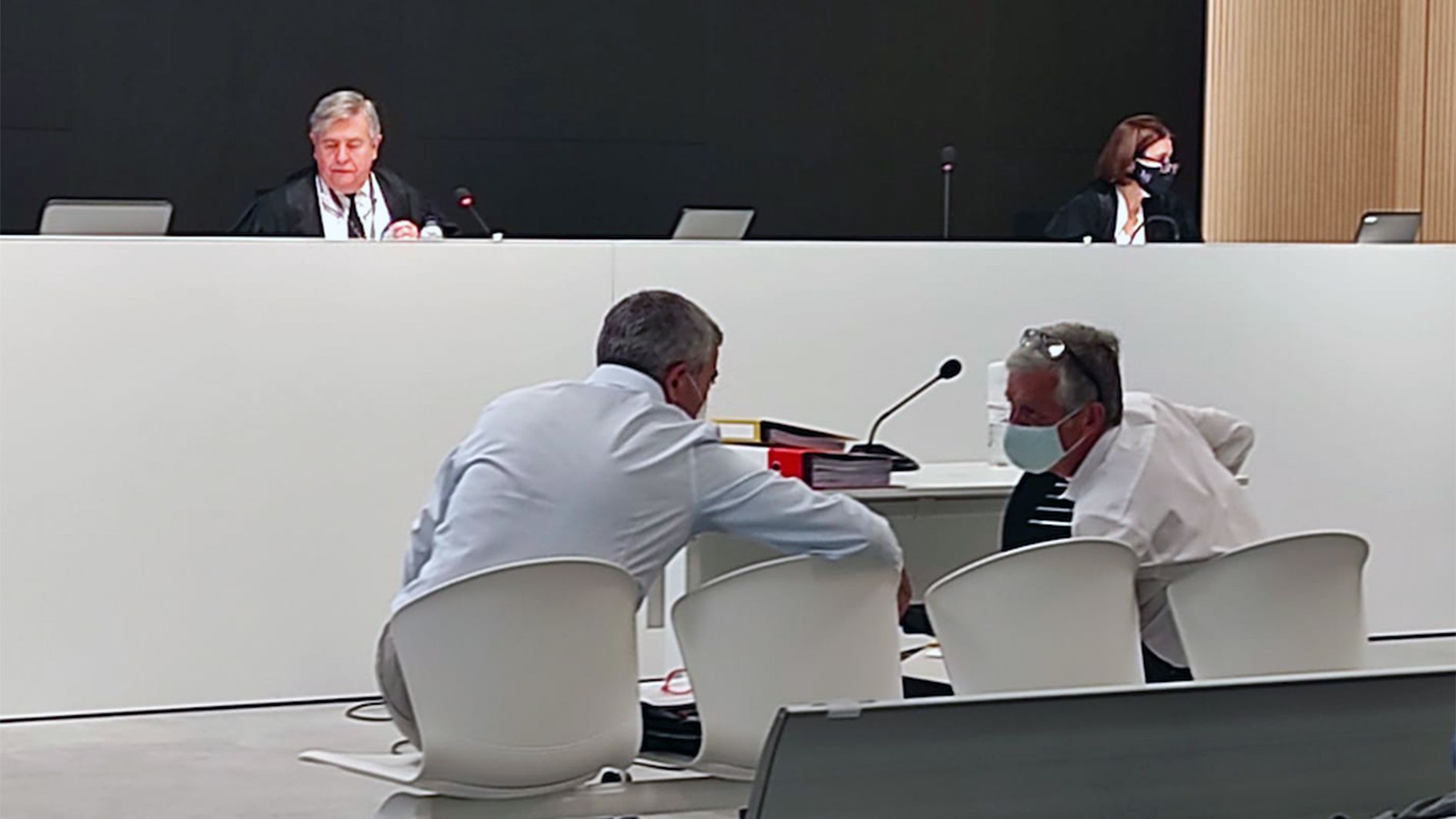 Joan Pau Miquel i el número 2 de BPA conversant en una sessió prèvia del judici, amb la magistrada implicada al fons a la dreta.