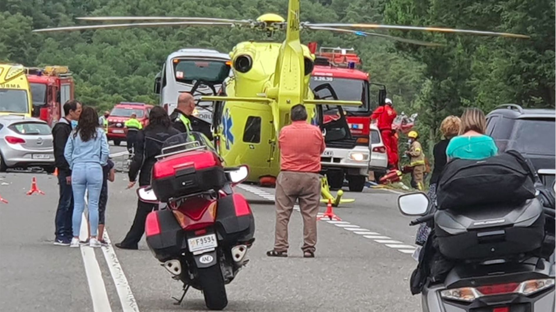 L'helicòpter sanitari esperant per endur-se la ferida del cotxe andorrà, que es veu molt parcialment a la dreta.