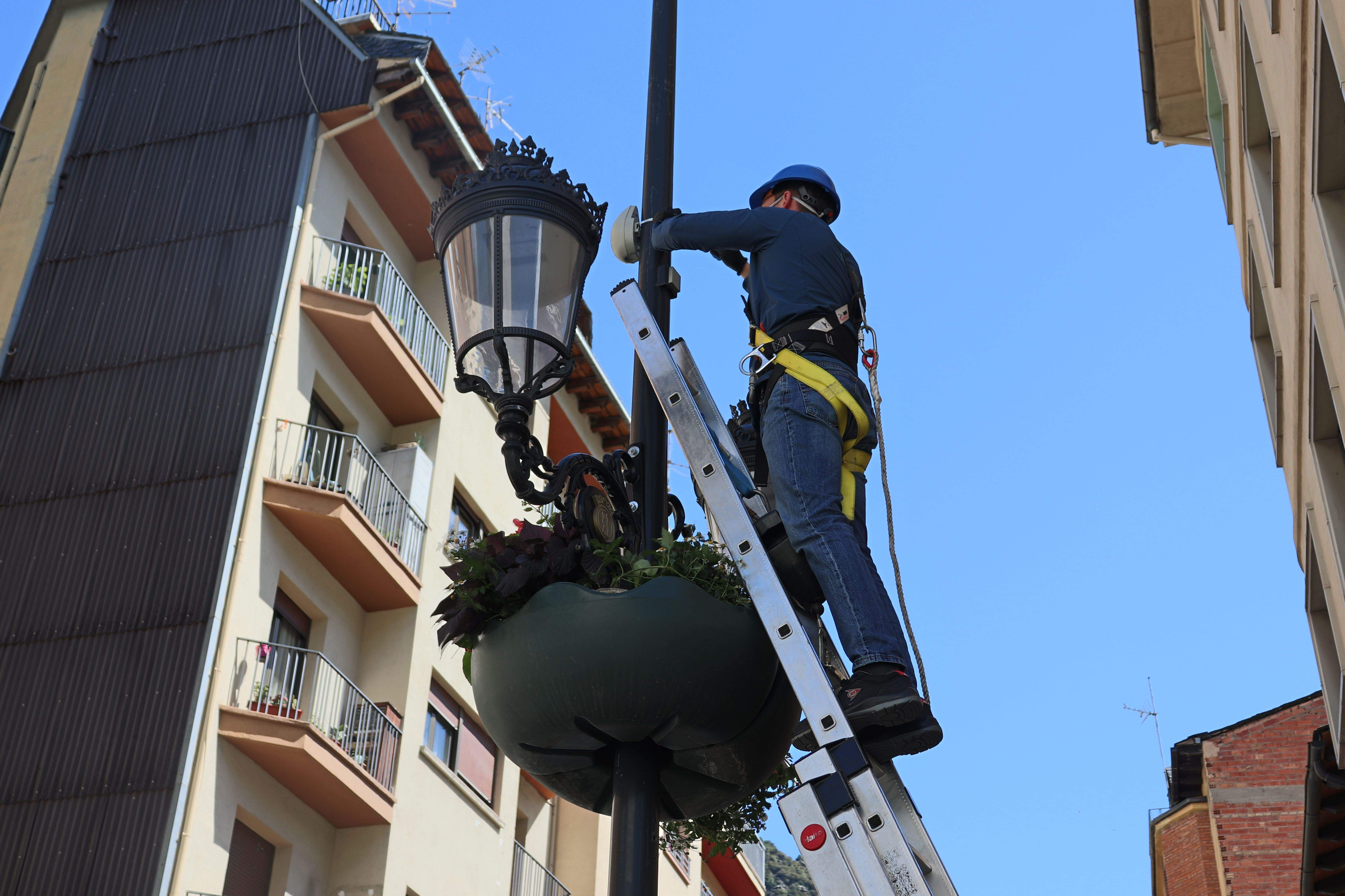 Un dels operaris col·locant el dispositiu de registre a un fanal
