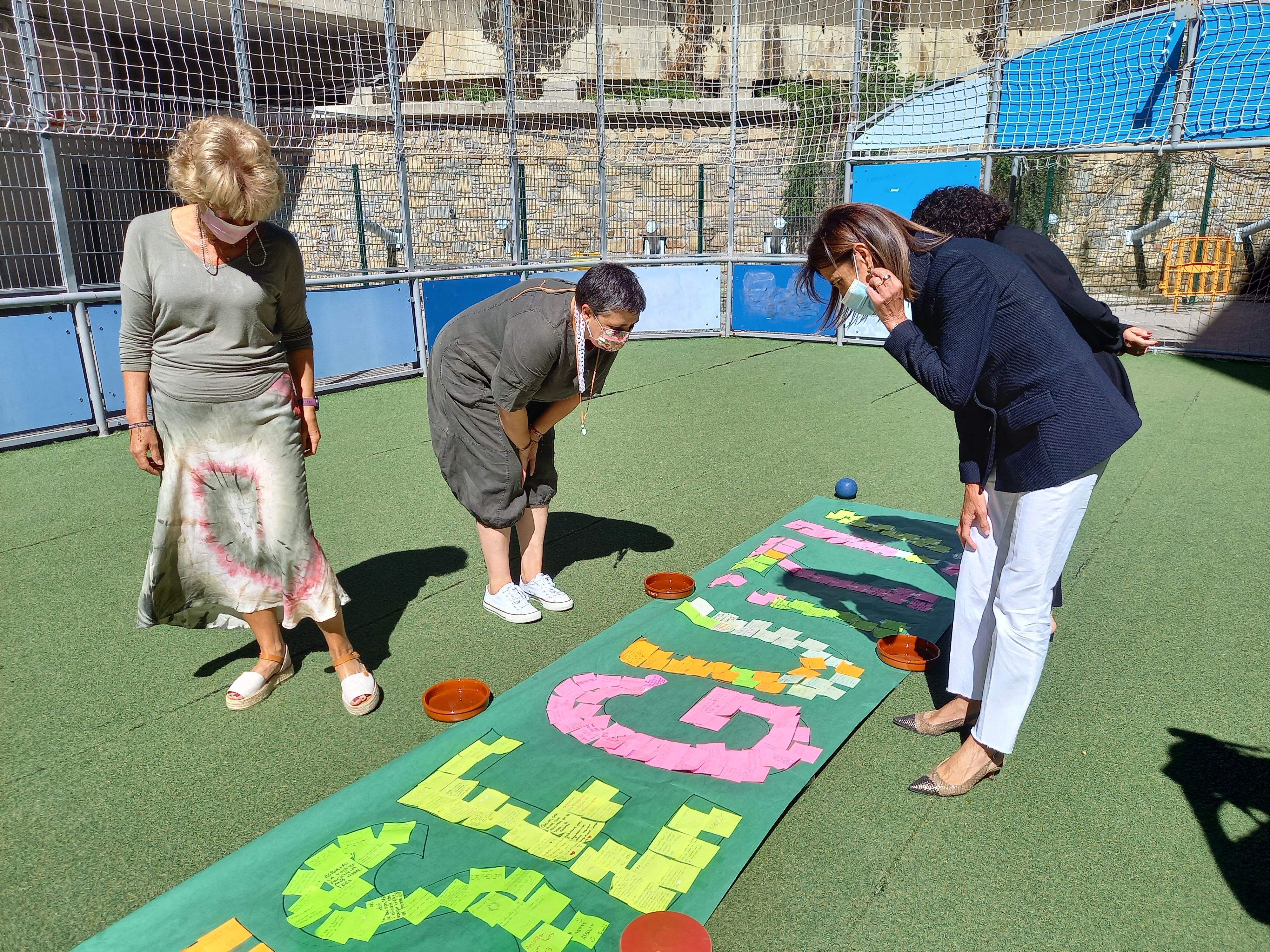 Vilarrubla i altres professors de l'escola andorrana miren el cartell fet pels alumnes.