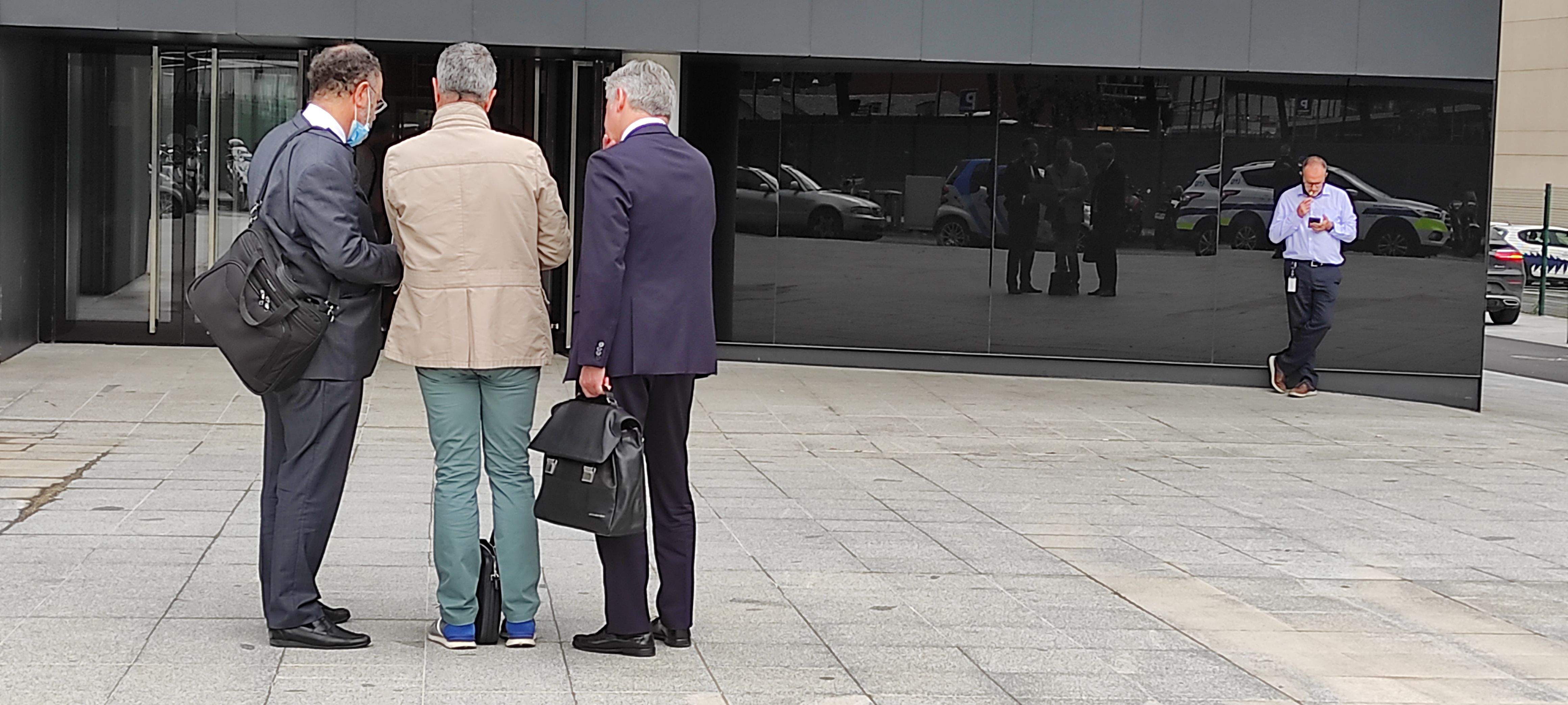 Joan Pau Miquel, amb jaqueta clara, entre dos advocats defensors, just abans d'accedir a la Seu de la Justícia aquest dimecres.