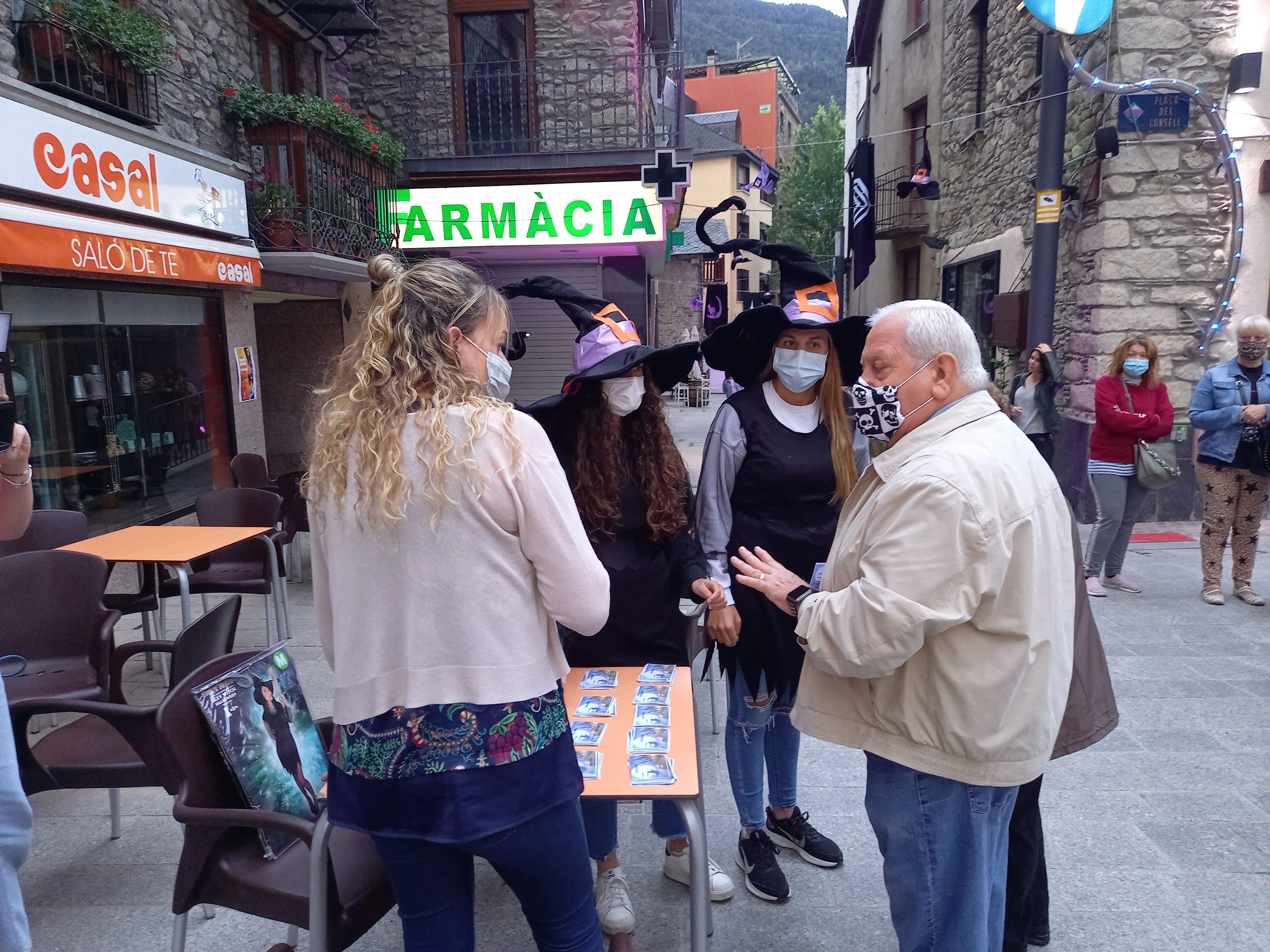 Dues bruixes reben als visitants del mercat.