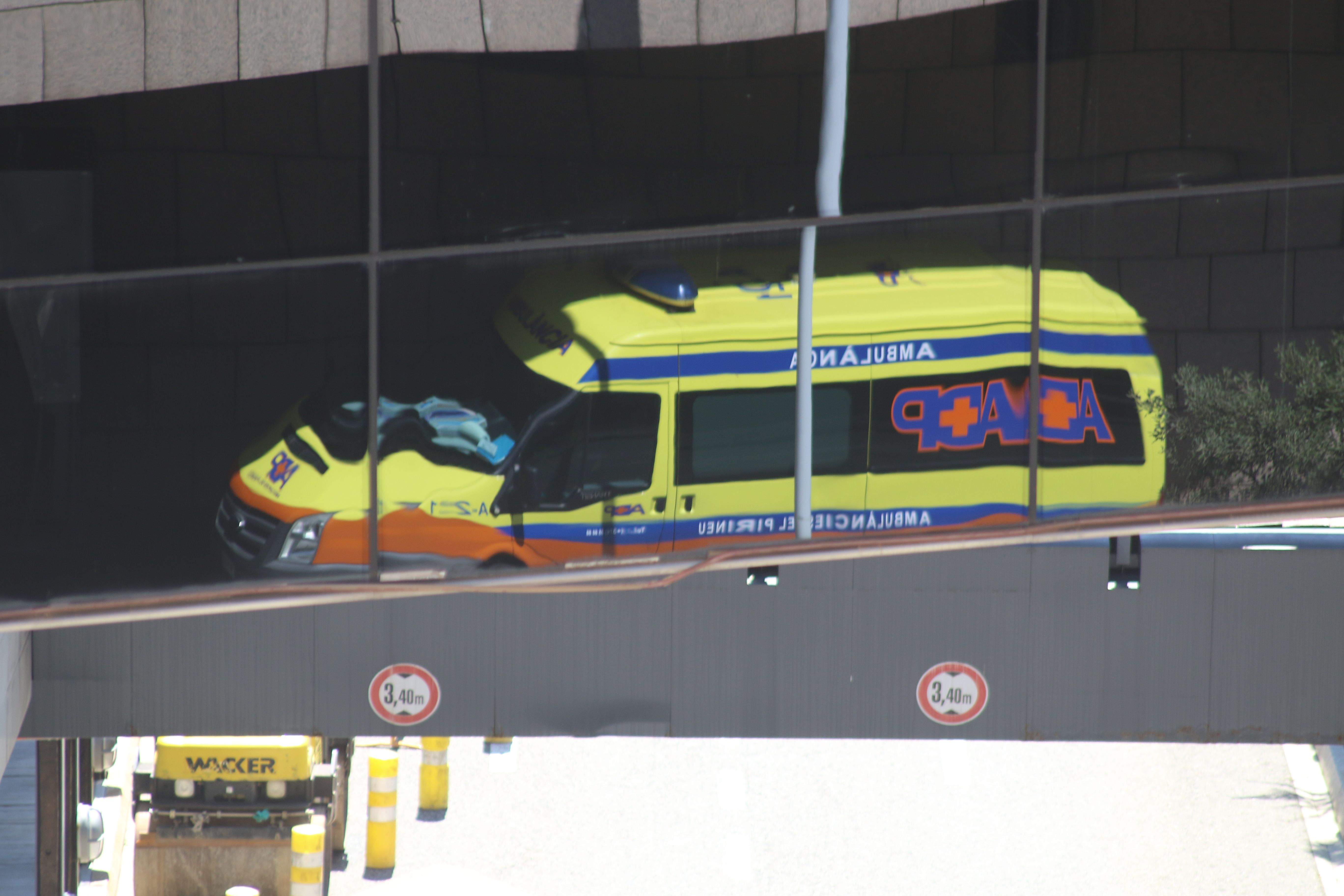 Una ambulància de l'actual concessionari estacionada a l'hospital i reflectida en uns vidres.