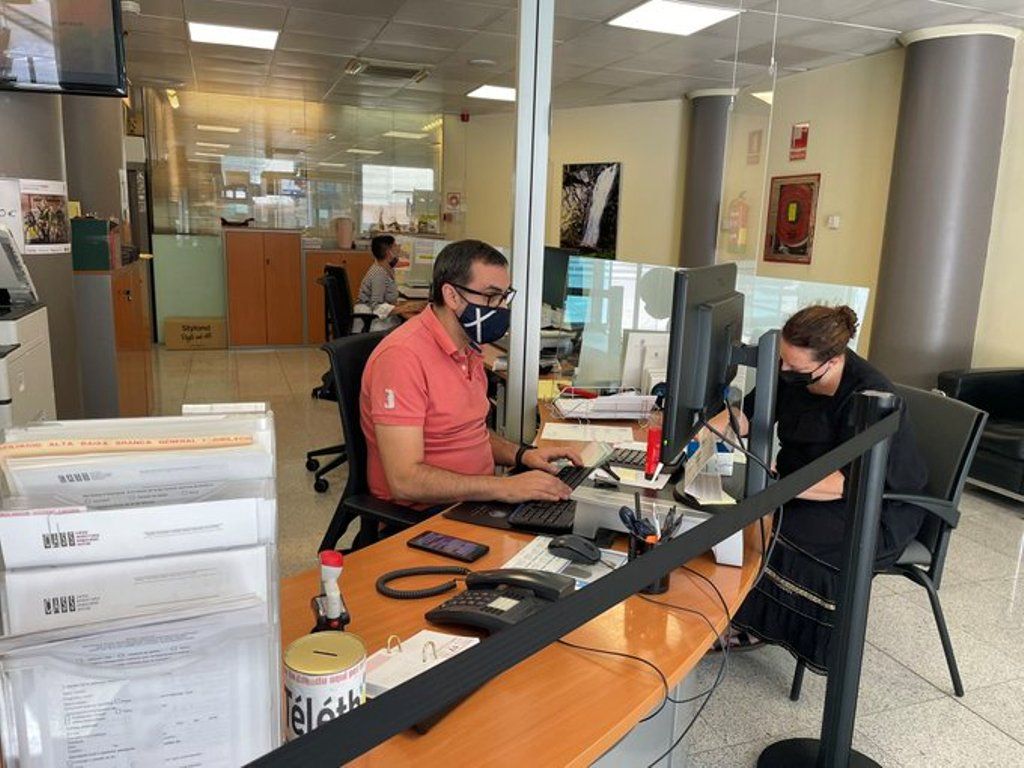 Un treballador de Tràmits de Sant Julià atén una usuària aquest dimarts.