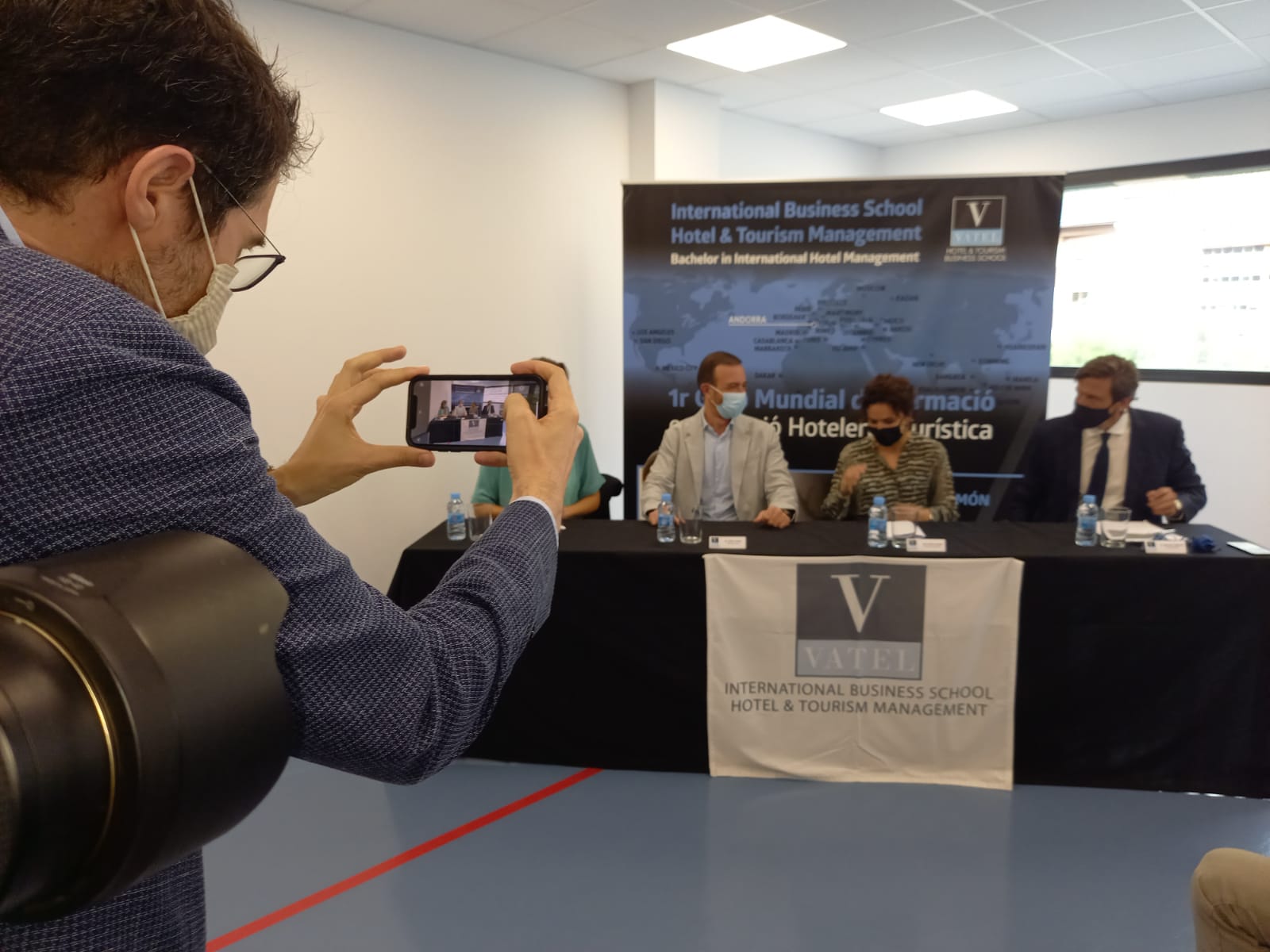 Un dels assistents fa una foto a la taula dels participants en la cerimònia.