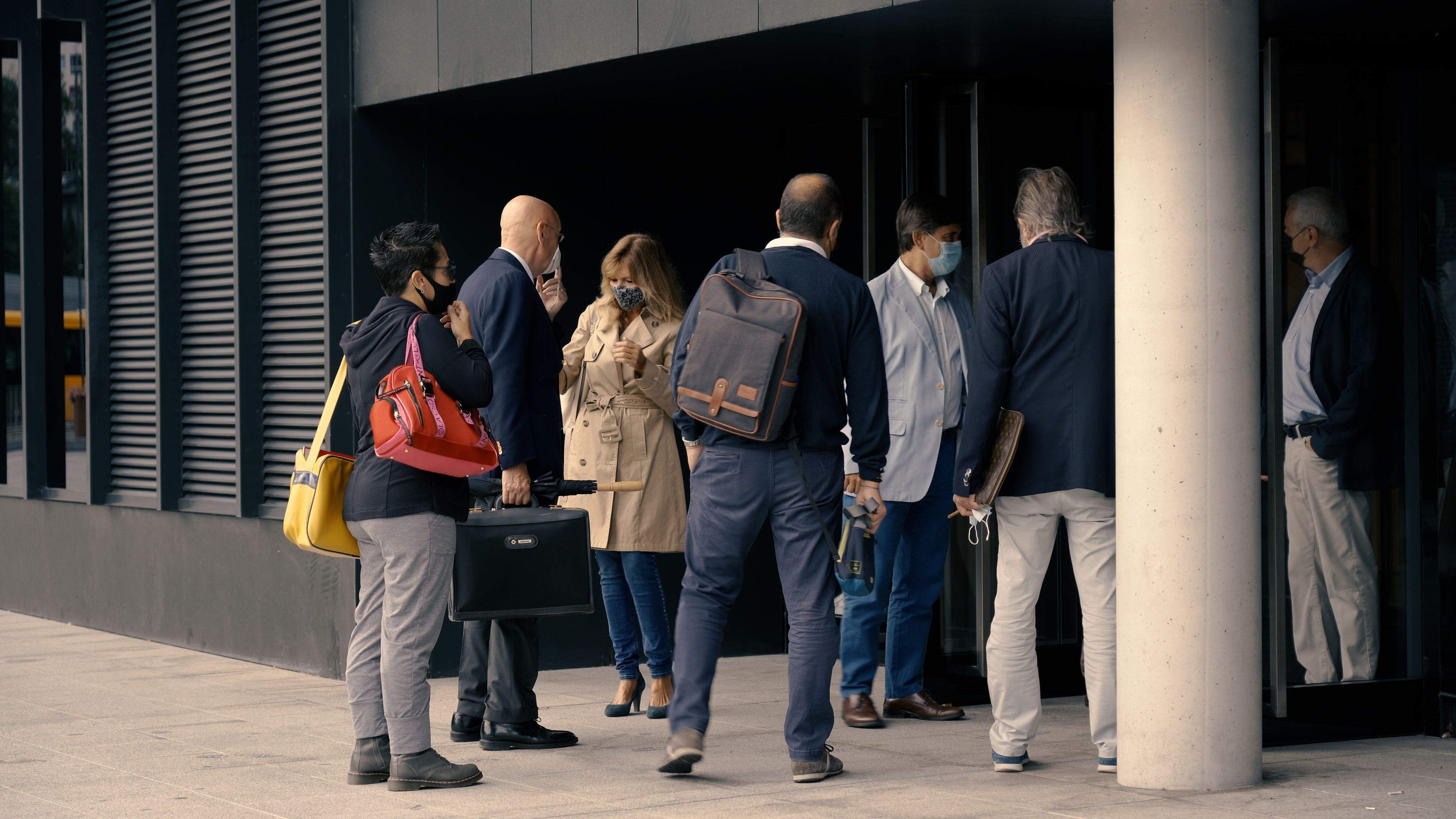 Processats i advocats accedint cap a la seu judicial.