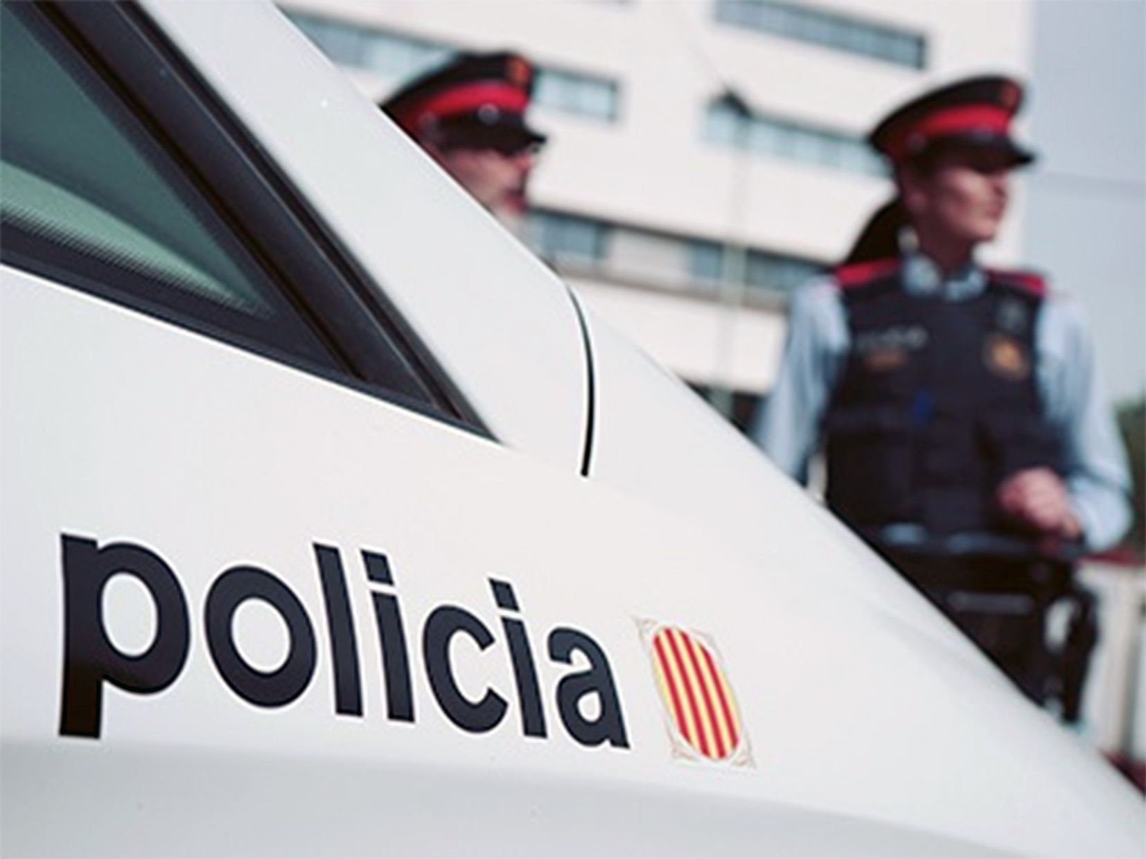 Imatge d'un vehicle i dos agents dels mossos.