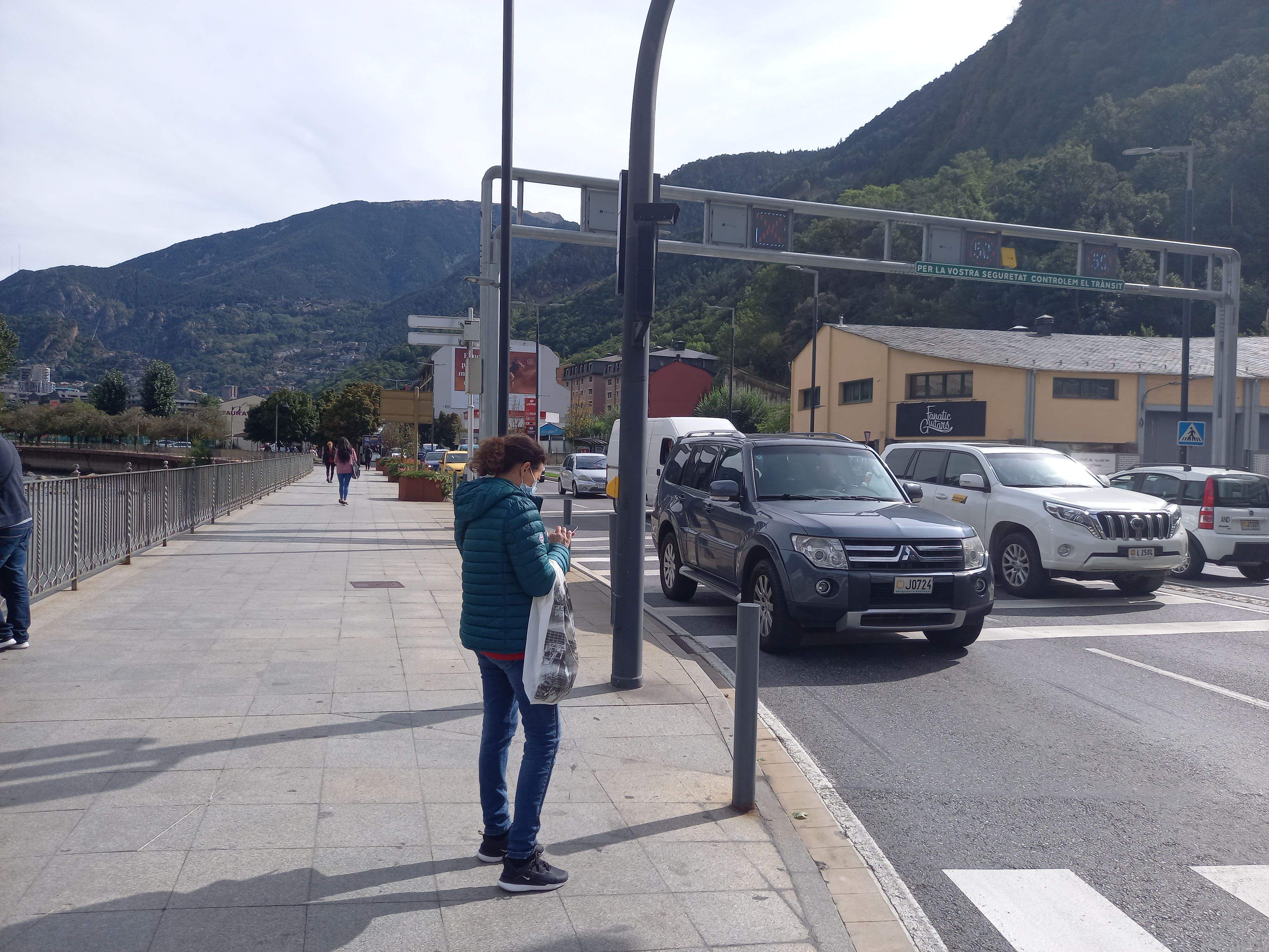 Una vianant espera el semàfor mentre el trànsit és intens a l'avinguda Tarragona.