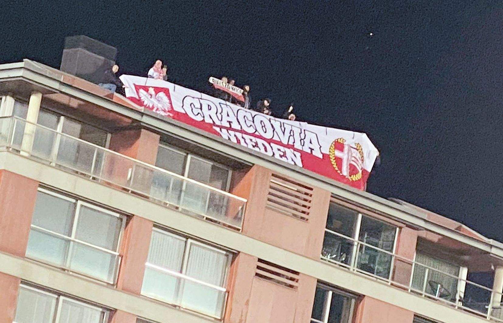 Aficionats polonesos al teulat d'un edifici proper a l'Estadi Nacional.