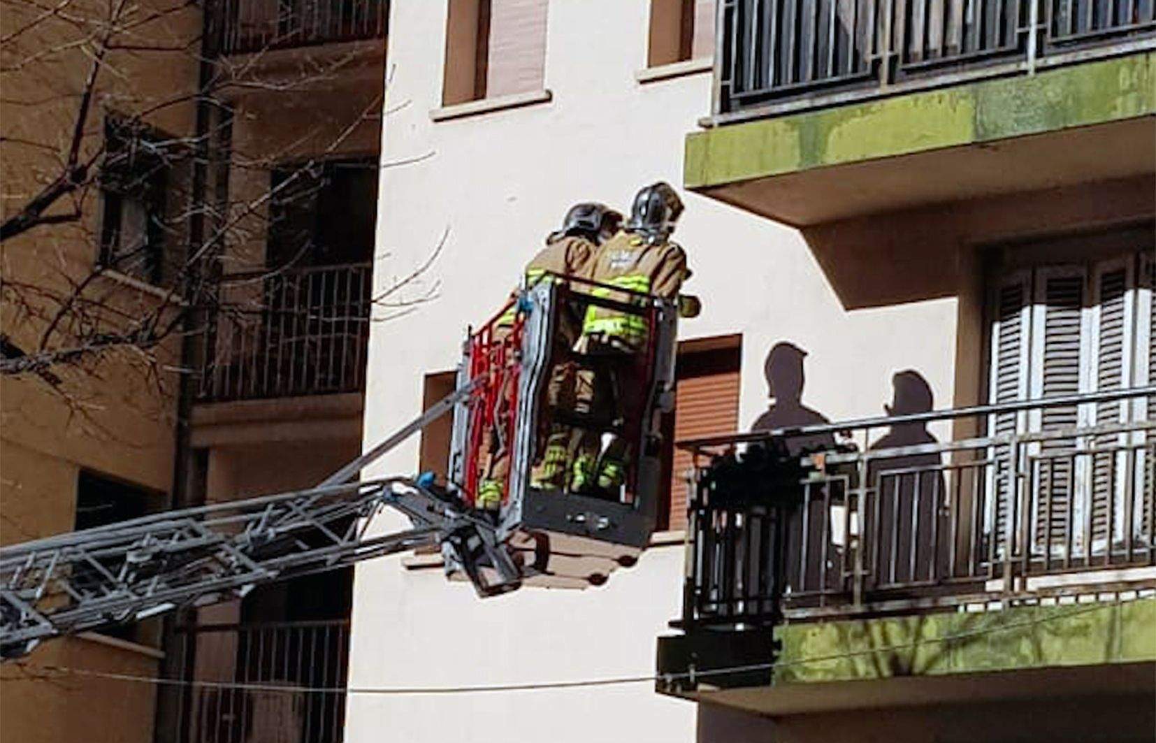 Dos bombers revisant la façana.